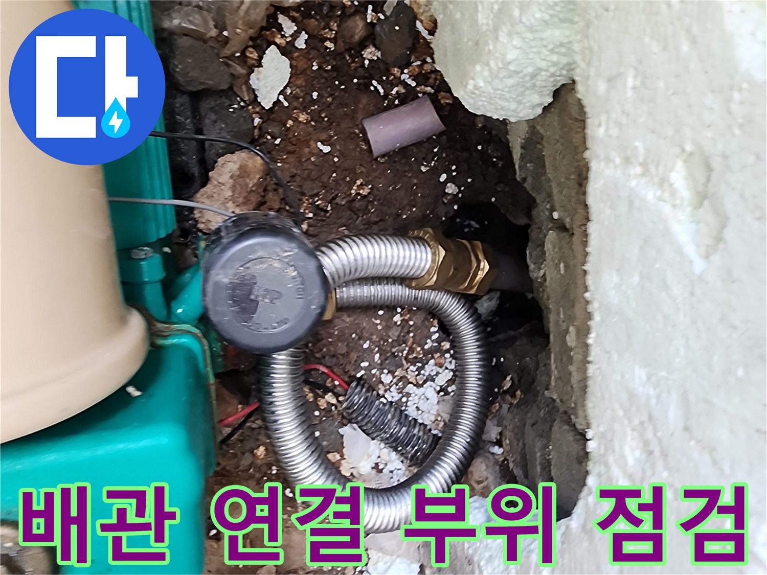 굴착된 벽면 사이로 보이는 금속 주름관과 배관 부속