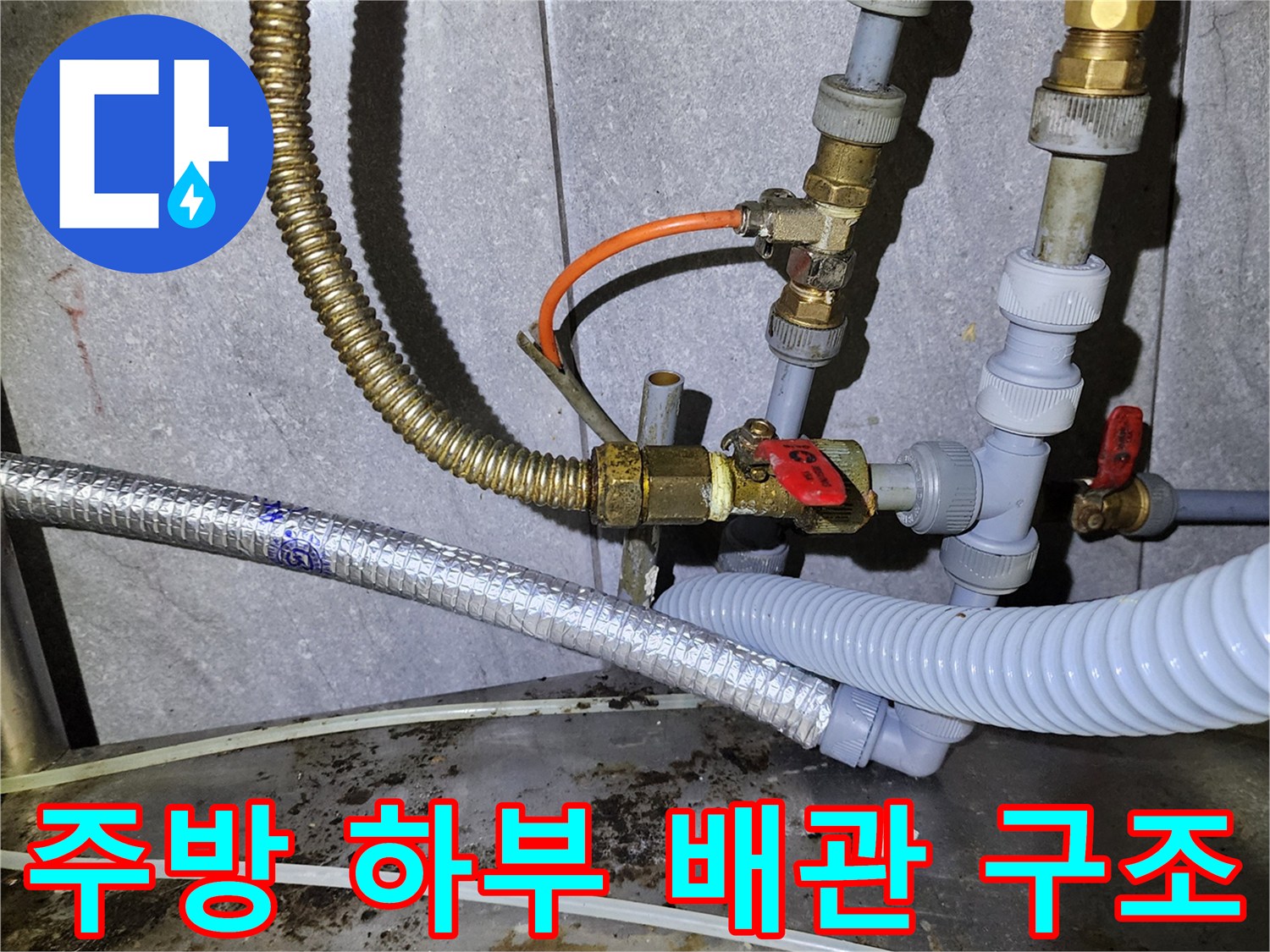 금속 호스와 PVC 관이 연결된 복잡한 배관 설비 모습