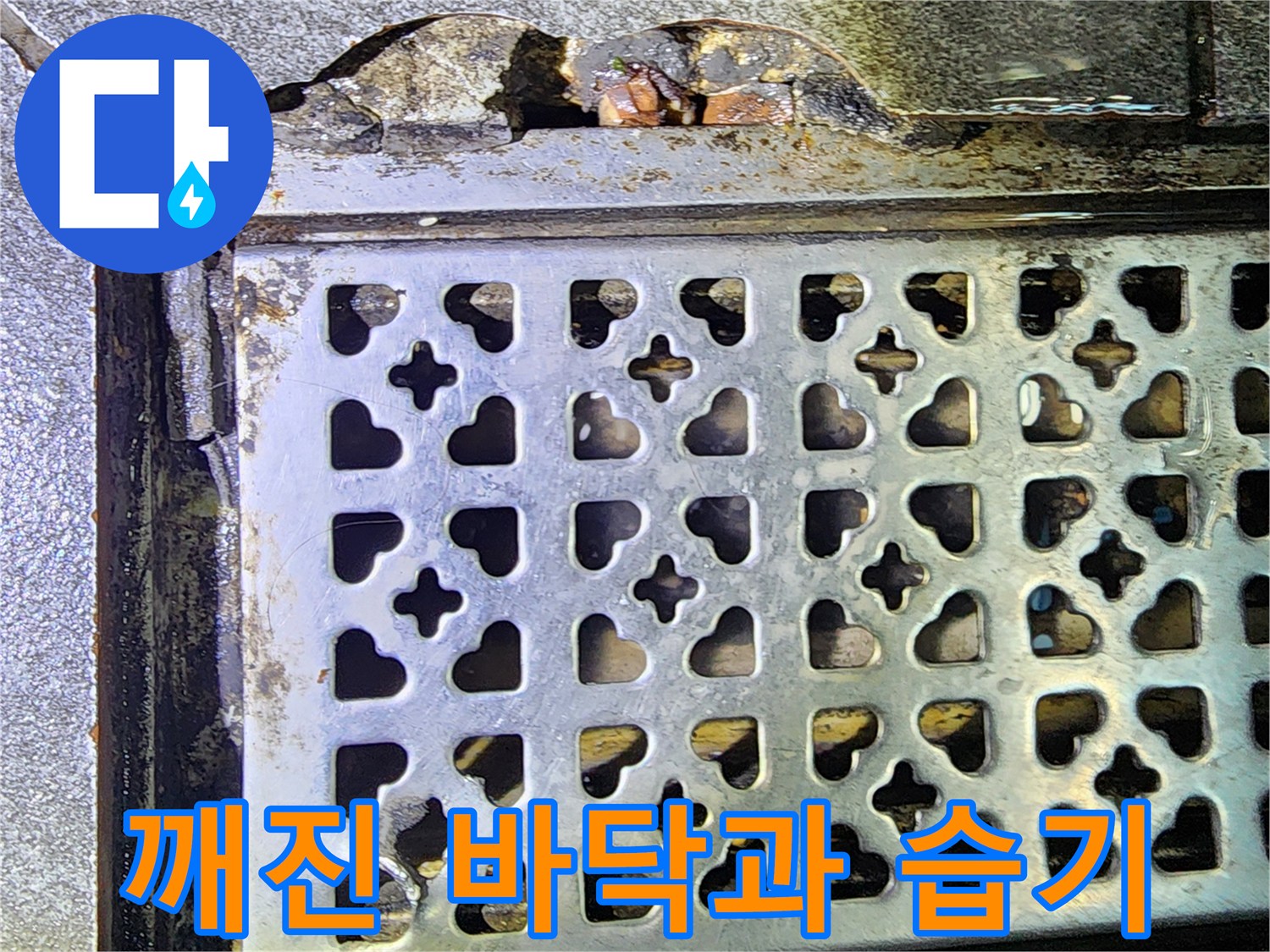 주방 트렌치 격자 덮개 옆의 파손된 마감재와 젖은 지면