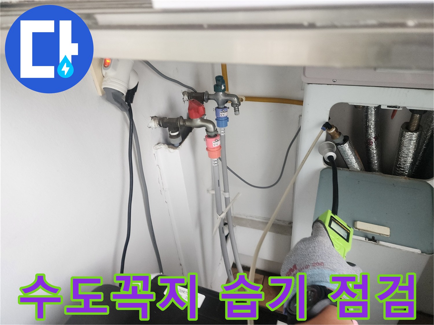 세탁실 수전 부근의 벽면과 배관 연결부를 검사하는 작업자 손길입니다.
