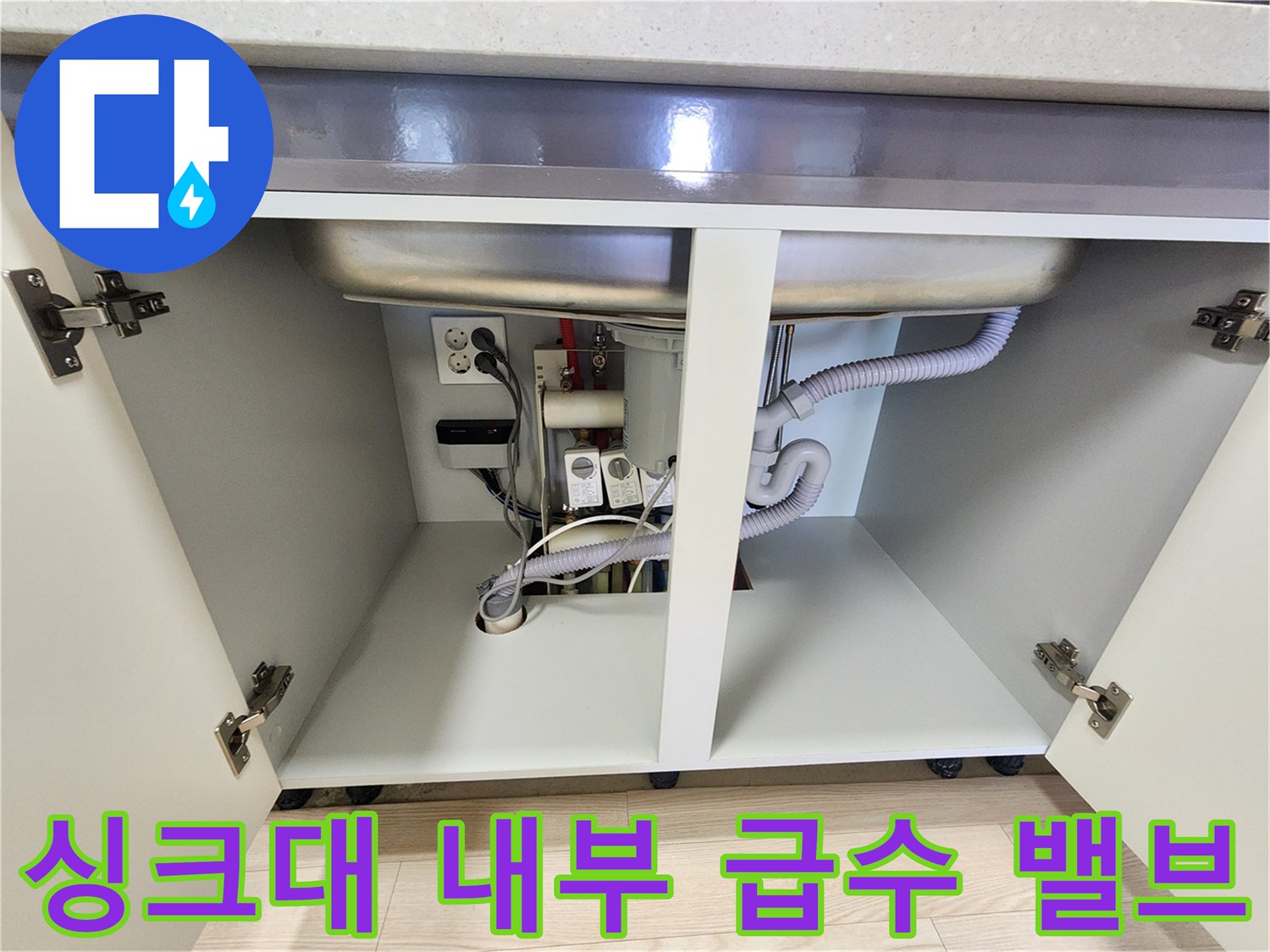 싱크대 하부장의 급수 밸브와 배수 호스 연결 부위 상세 사진