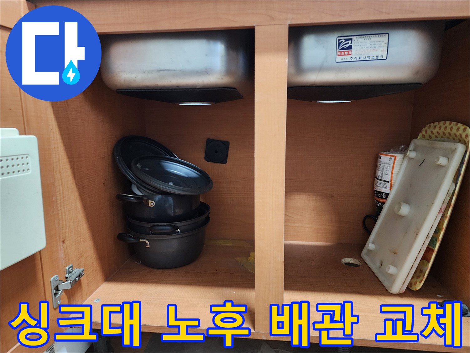 싱크대 하부장 내부 - 누수 지점을 찾기 위해 집중하고 있습니다.