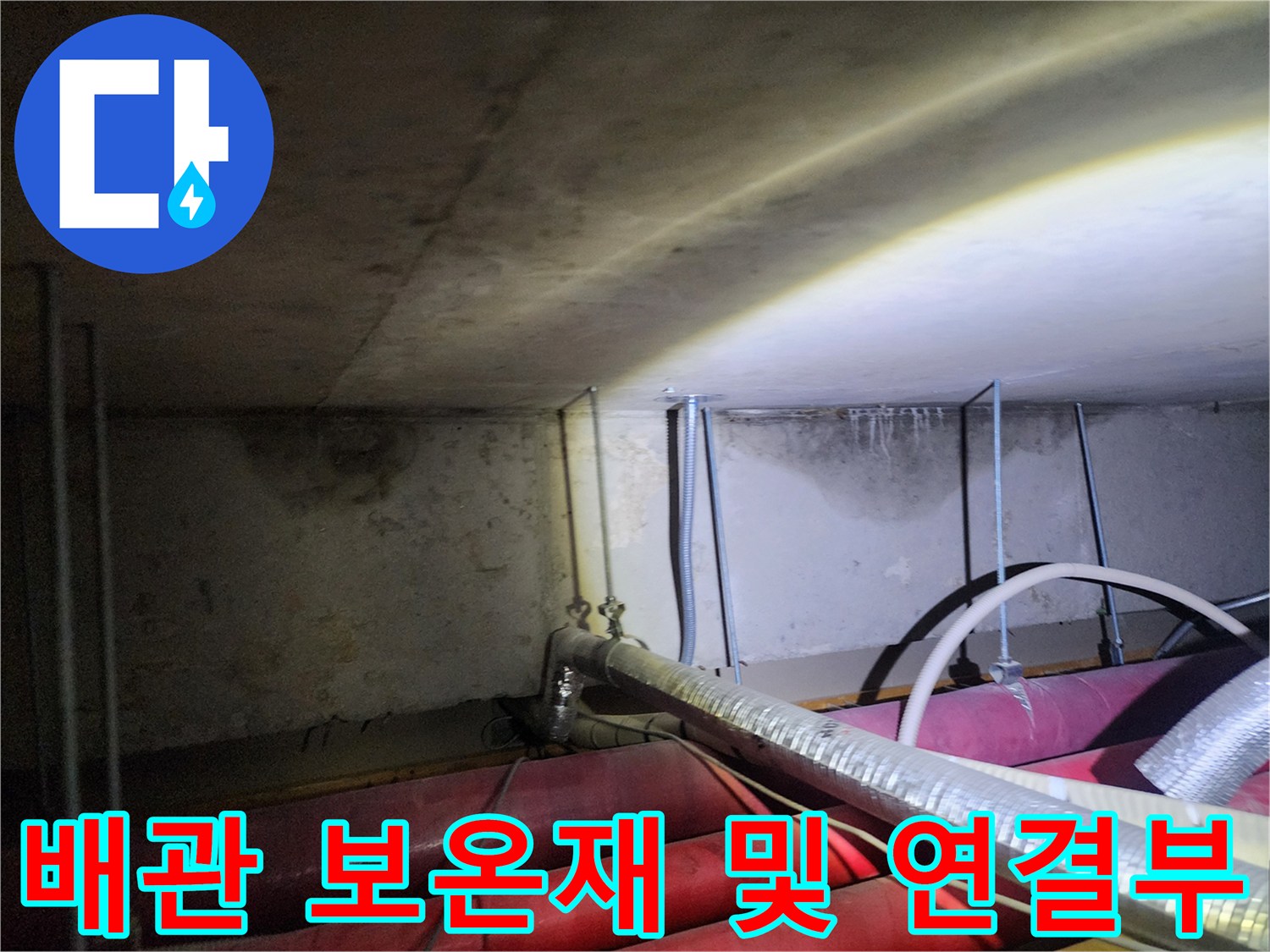 보온재로 감싸진 대형 배관과 수직 연결관의 현장 모습