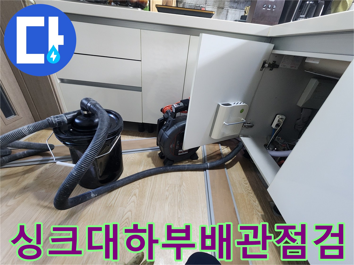 주방 싱크대 아래쪽 배수 호스 및 하부 공간 점검 모습