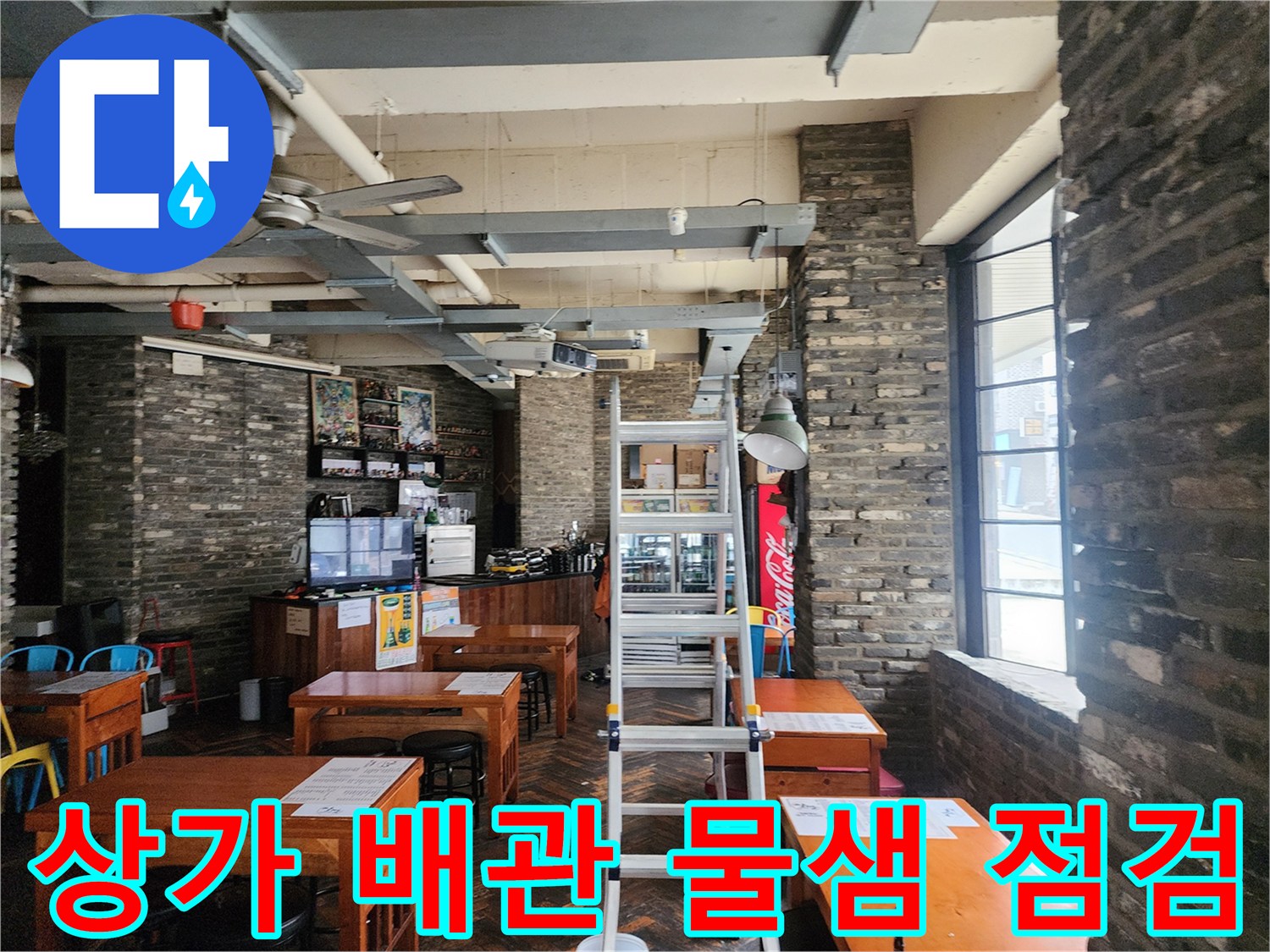 천장 노출 배관과 사다리가 배치된 상가 내부 모습