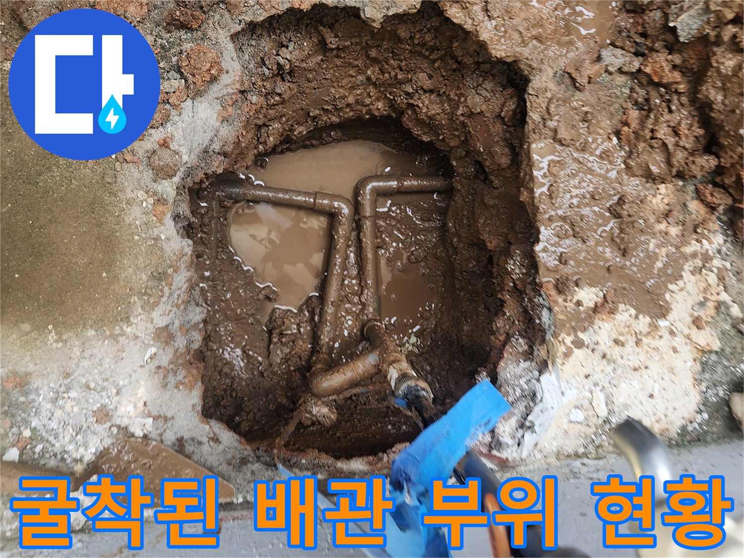 배관 주위의 젖은 토양과 드러난 배관 연결 부속