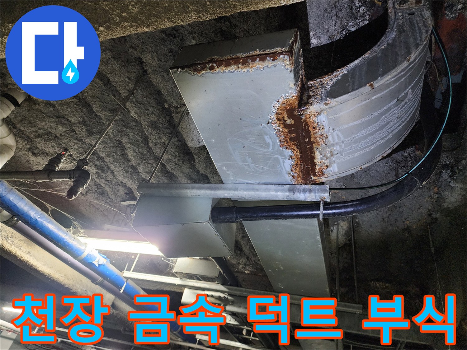 천장에 설치된 대형 금속 구조물의 녹슨 부위와 습기 흔적