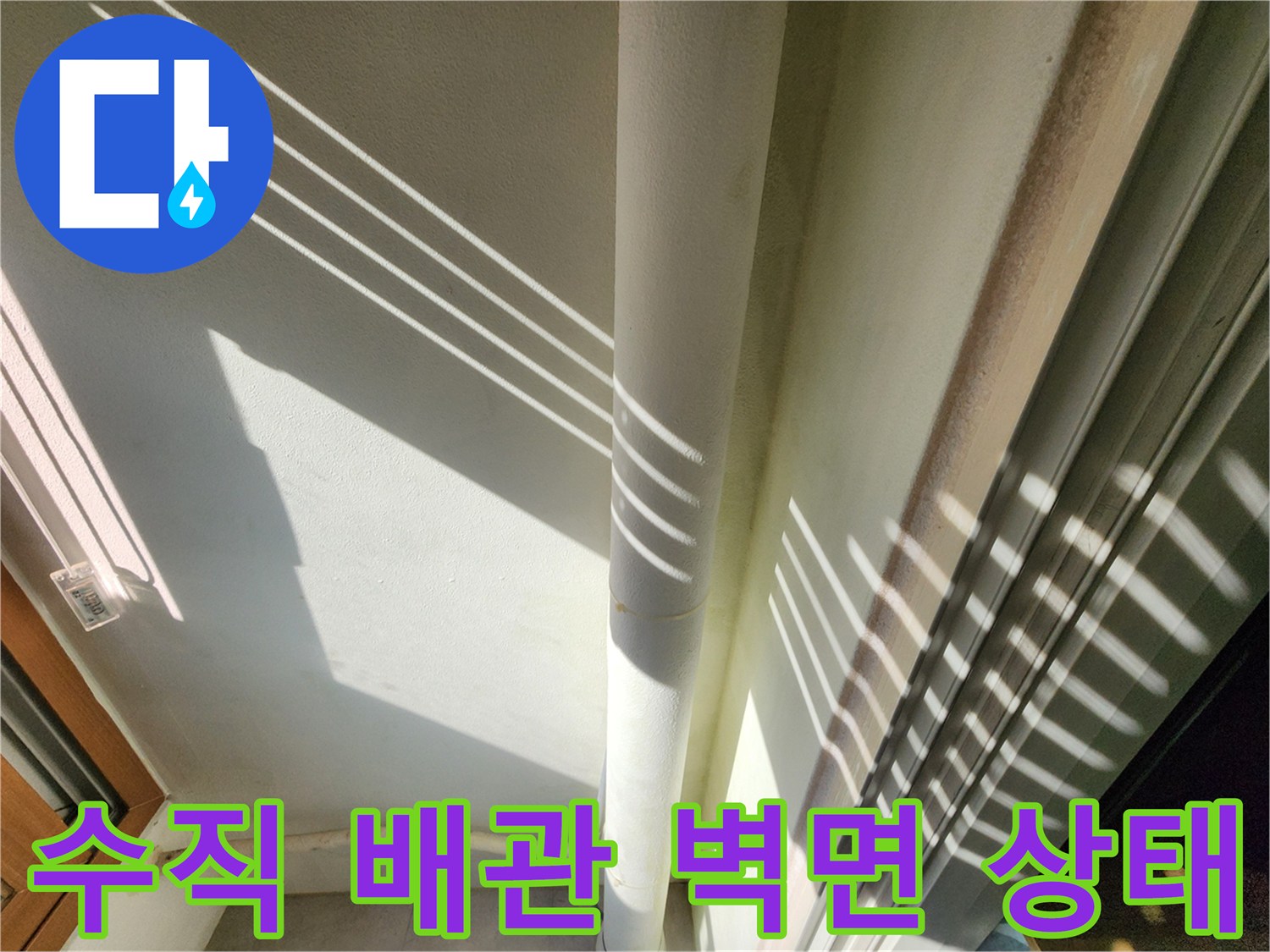 벽면에 고정된 수직 배관의 외관을 촬영하였습니다.