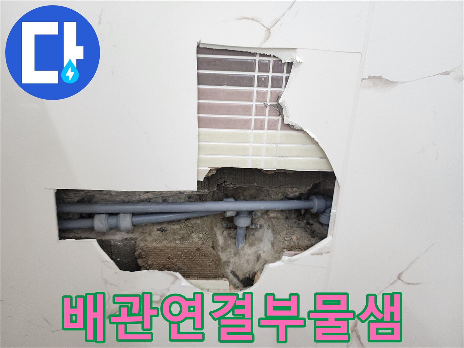 벽면 타일 제거 후 노출된 회색 수도 배관의 연결 소켓 부위