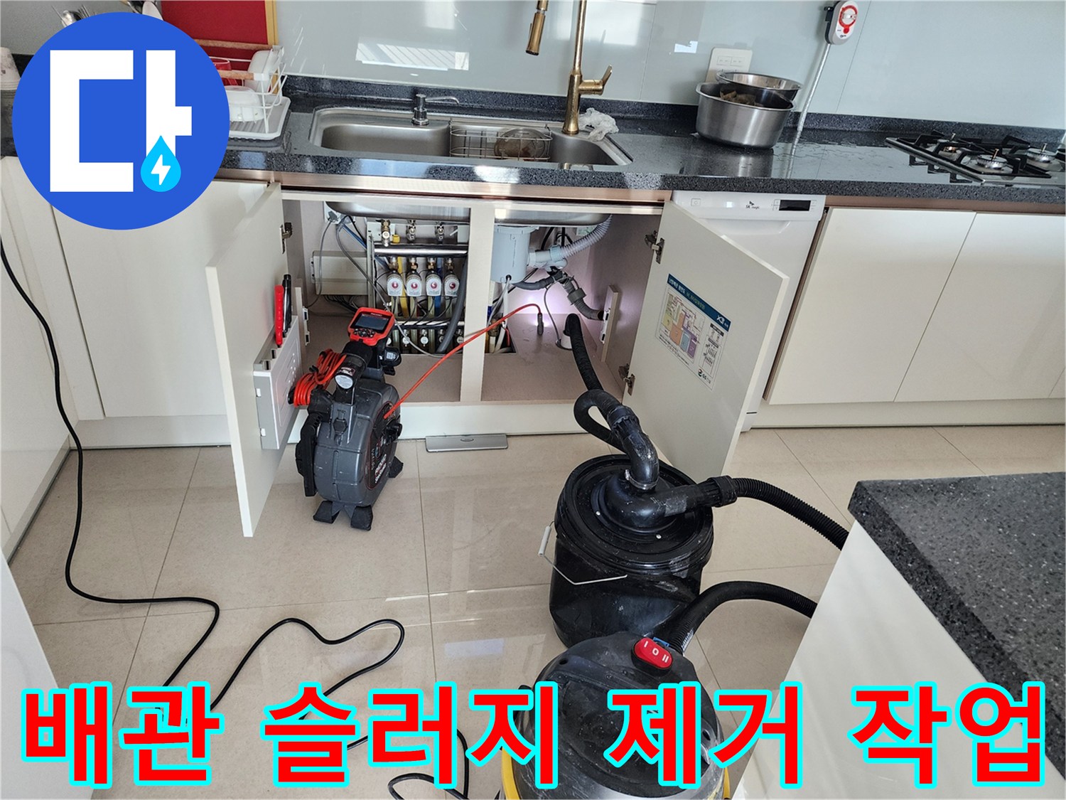 석션기와 배관 장비를 활용하여 싱크대 하부 배관을 청소하는 장면