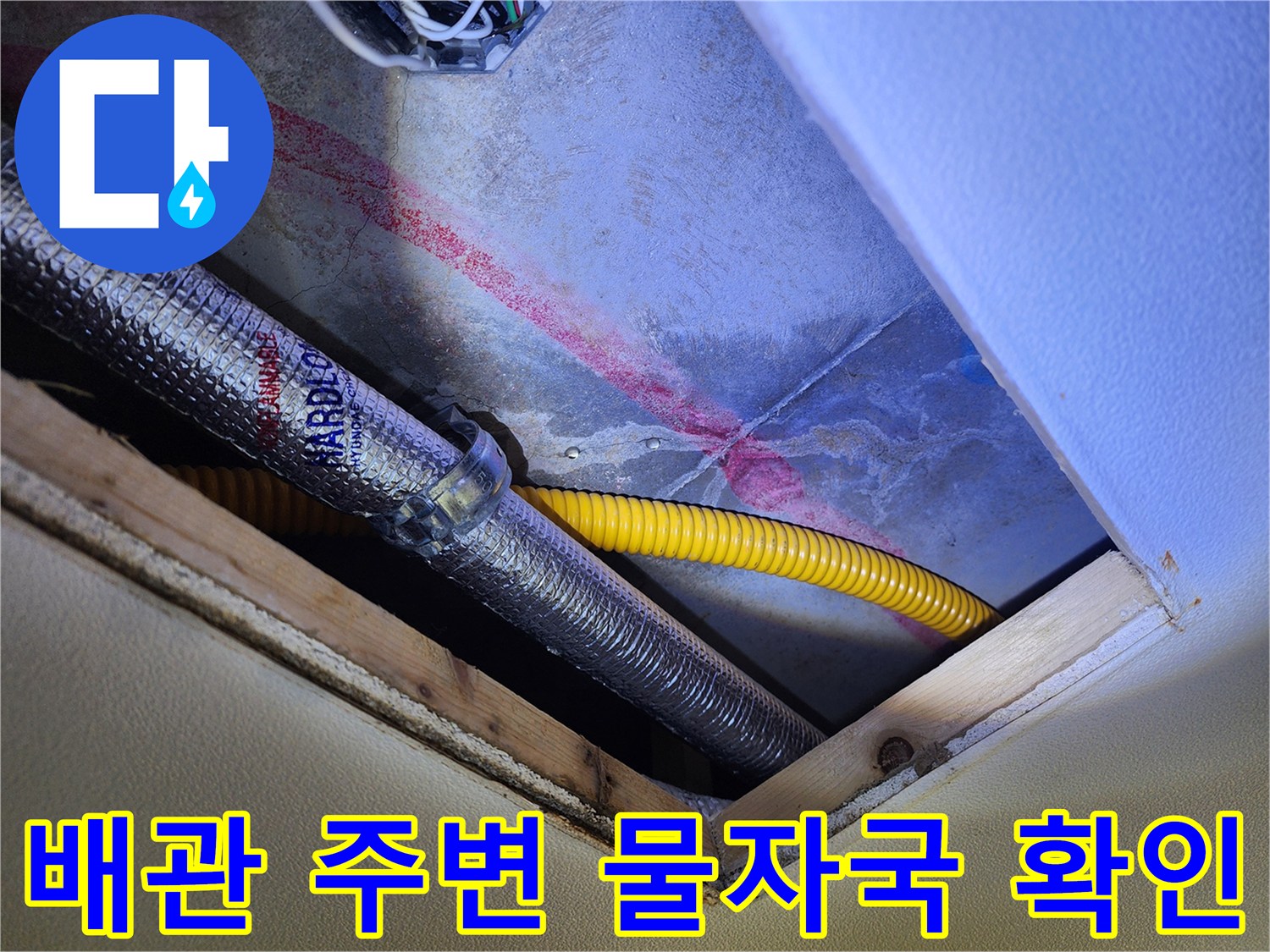 은색 배관과 노란 관 사이의 습기 젖은 흔적을 촬영한 사진입니다.