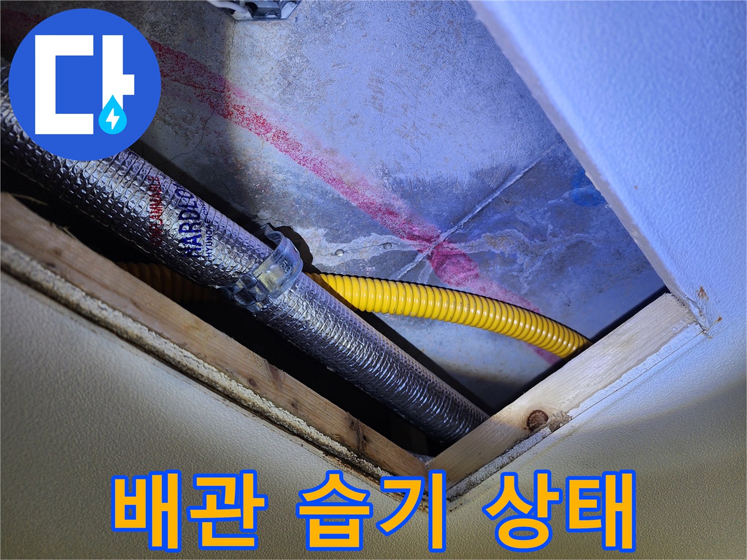 은색 보온재와 노란색 호스가 보이는 천장 내부의 물자국 부위