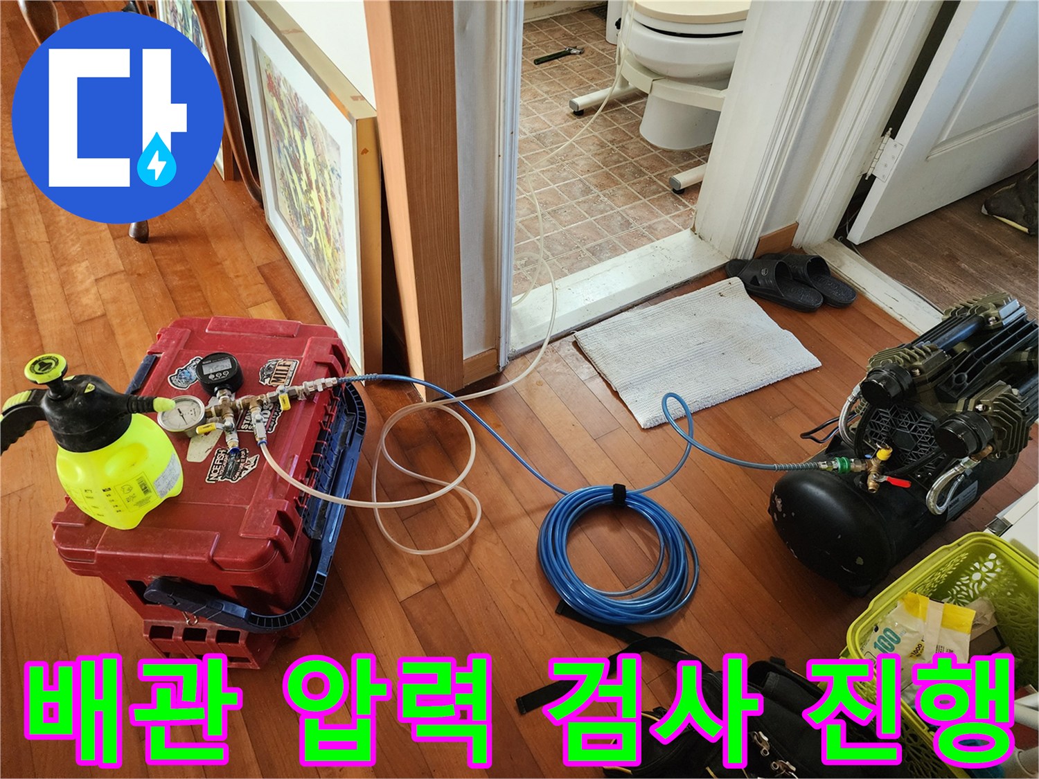 파란색 호스와 게이지를 통해 배관 내부의 압력을 측정하고 있습니다.