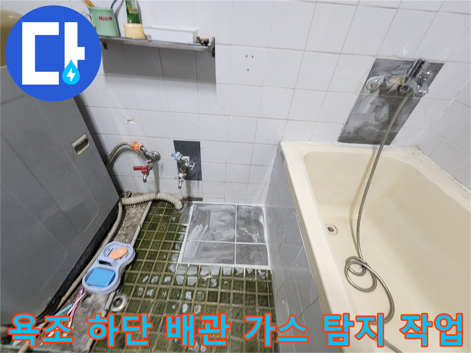 욕조 주변 타일 부근의 수도 배관 누출 여부를 검사하는 장면입니다.
