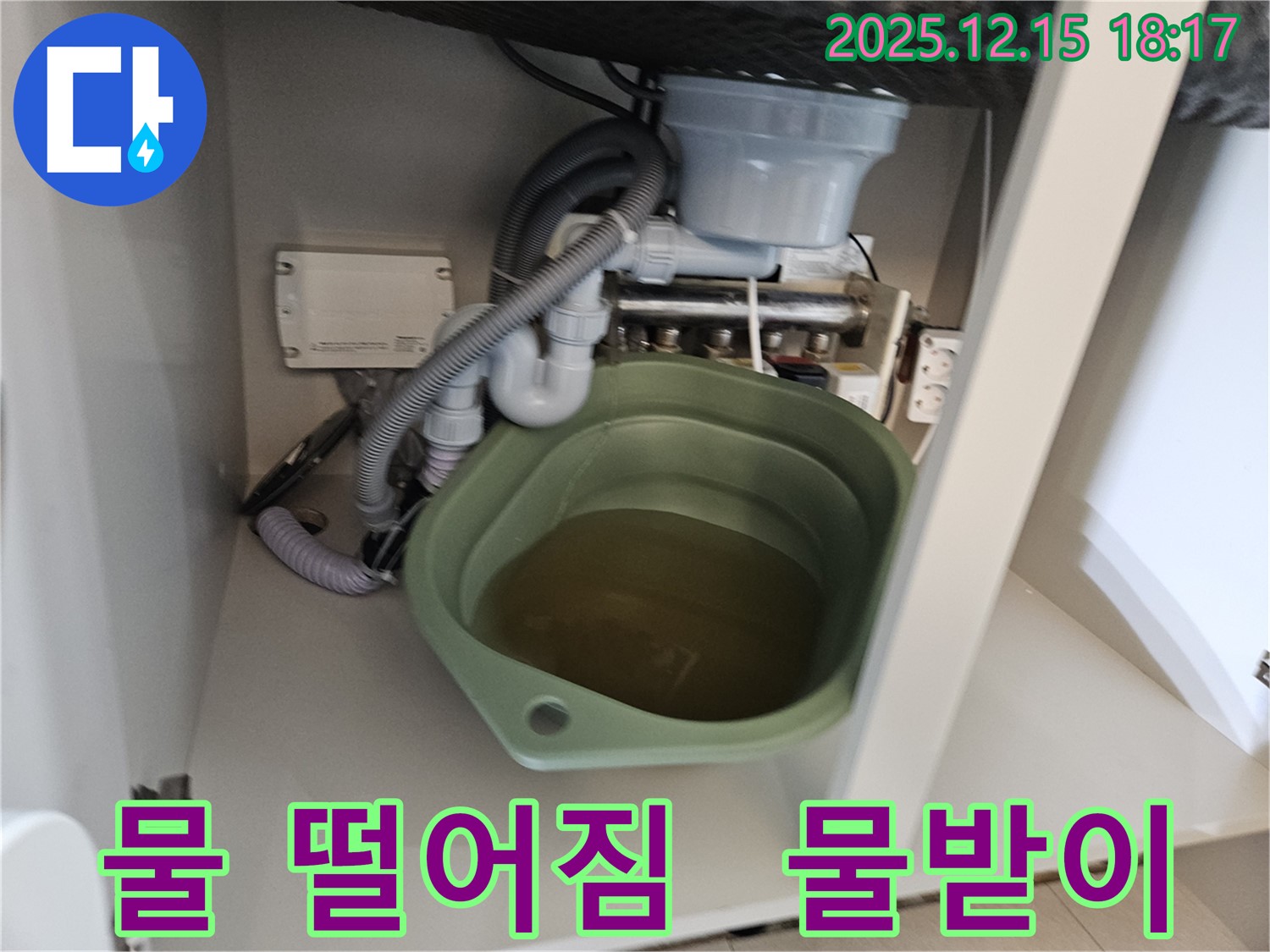 싱크대 밑에서 물이 떨어지는 모습 - 누수의 초기 증상일 수 있습니다. 물받이를 확인하고 전문가에게 즉시 문의하세요.