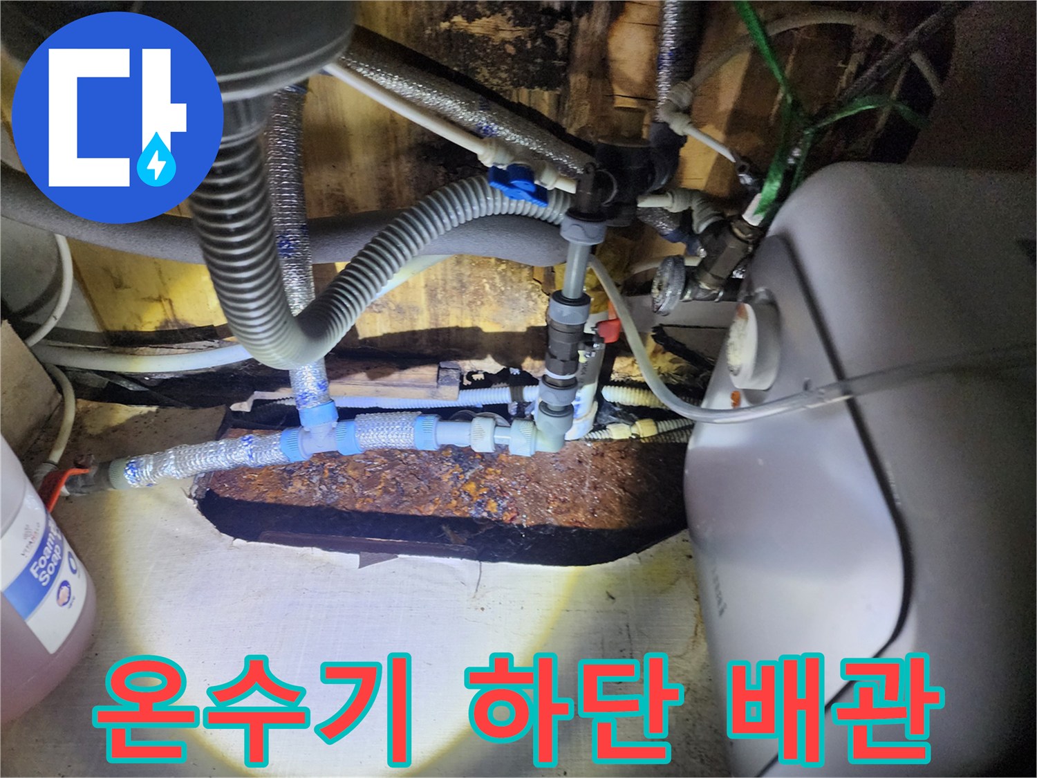 온수기 본체와 연결된 유연한 호스 및 금속 배관들