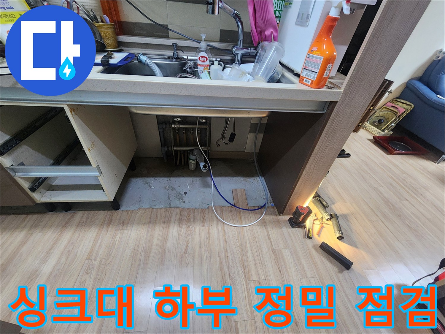 밝은-조명을-사용하여-싱크대-하부의-어두운-곳까지-세밀하게-점검하며-누수-흔적을-찾는-과정