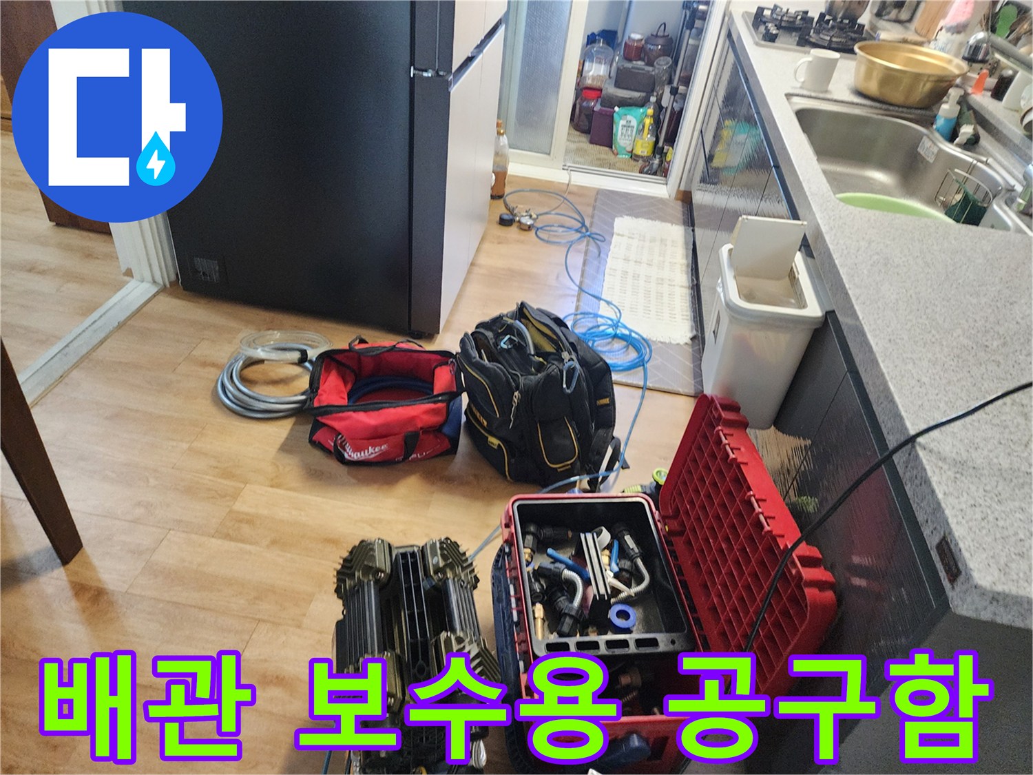 바닥에 놓인 배관 수리용 부속과 전문 공구 세트