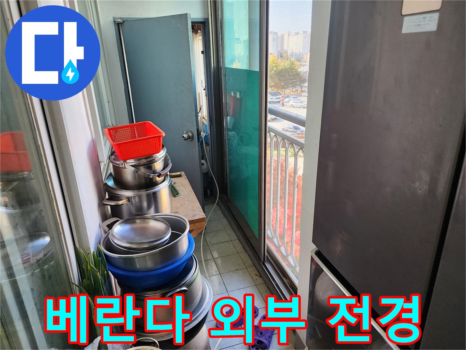 창문 너머로 보이는 아파트 단지와 베란다 내부 공간 - 누수 탐지 작업 중입니다.