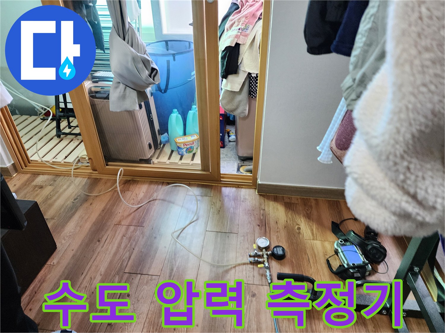 바닥에 설치된 배관 점검용 압력계와 연결 호스 - 누수 지점 탐색 작업 중