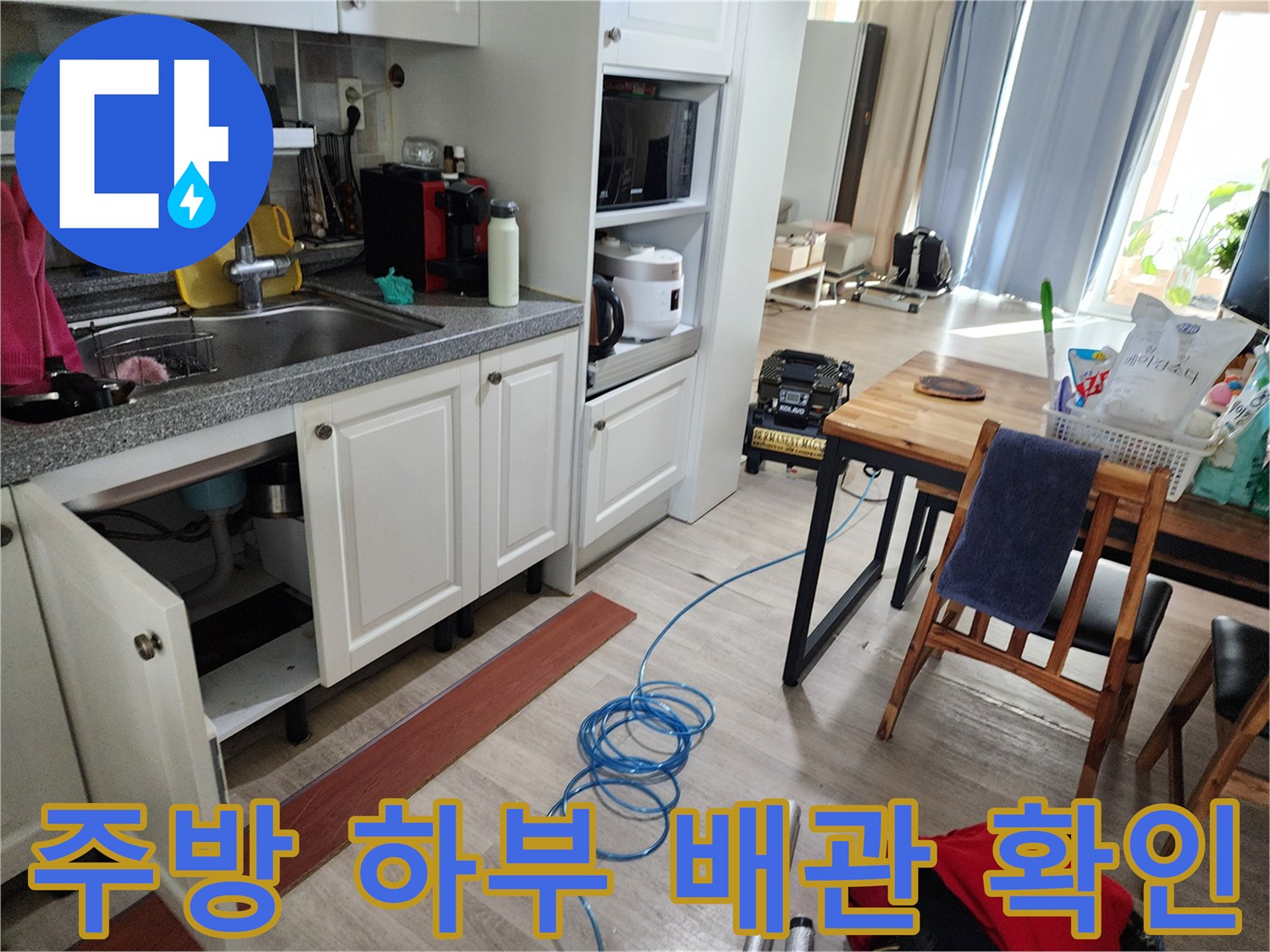 싱크대 아래 공간의 배관 연결 부위 근접 사진