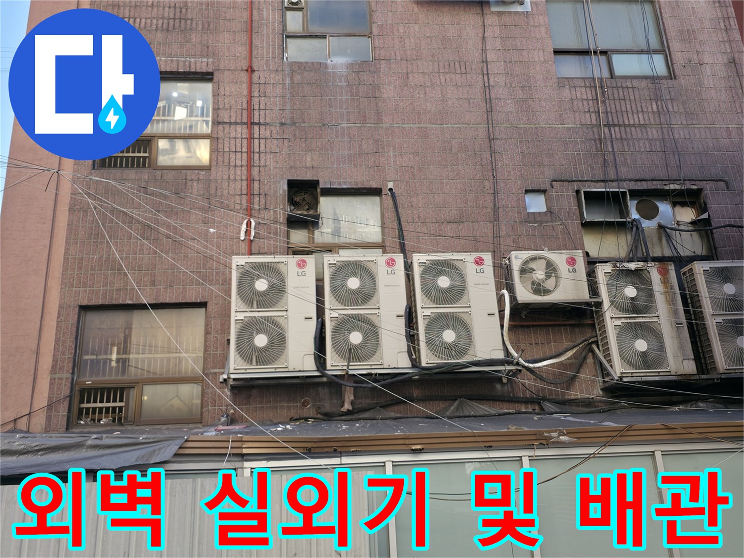 상가 건물 외벽에 설치된 에어컨 실외기와 연결 배관