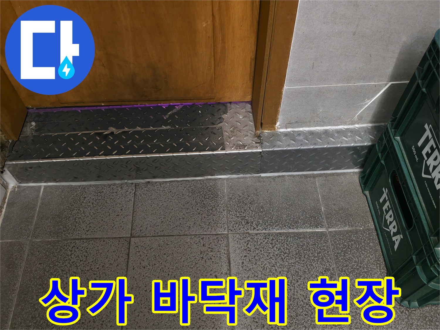 상가 매장 입구의 금속 마감재와 타일 바닥 상태를 보여주는 사진