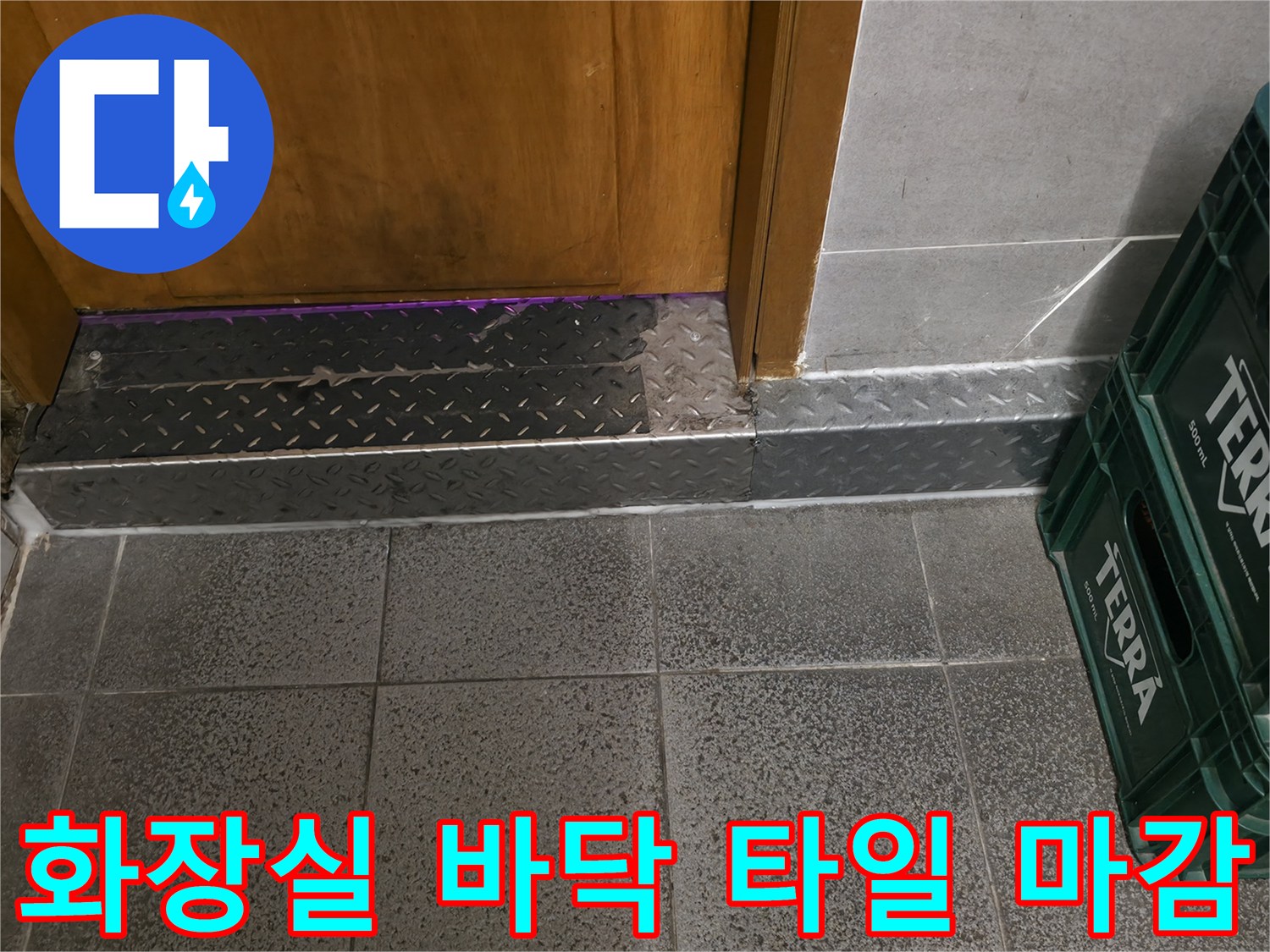 상가 화장실 입구의 젖어있는 듯한 타일과 문턱 금속재 모습입니다.
