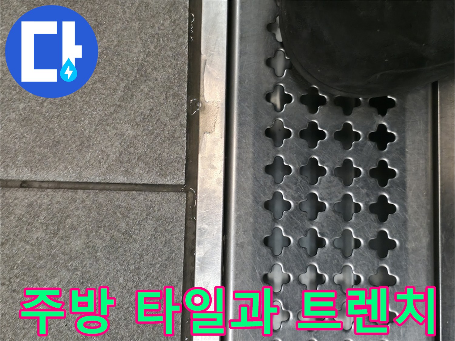 회색 타일 바닥과 스테인리스 배수 트렌치의 접합부