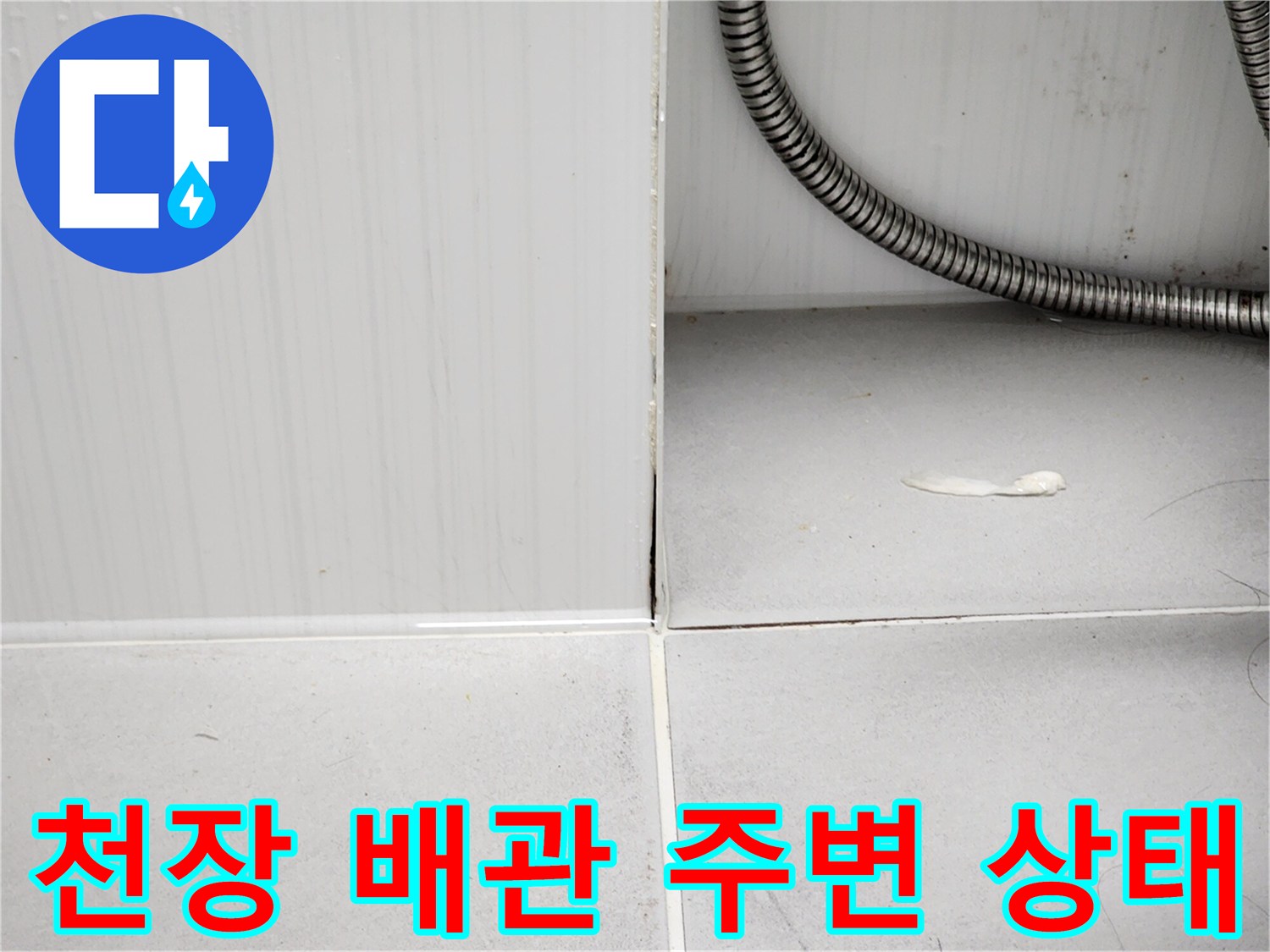 욕실 천장 점검구 내부-금속 재질의 주름관과 타일 틈새 확인