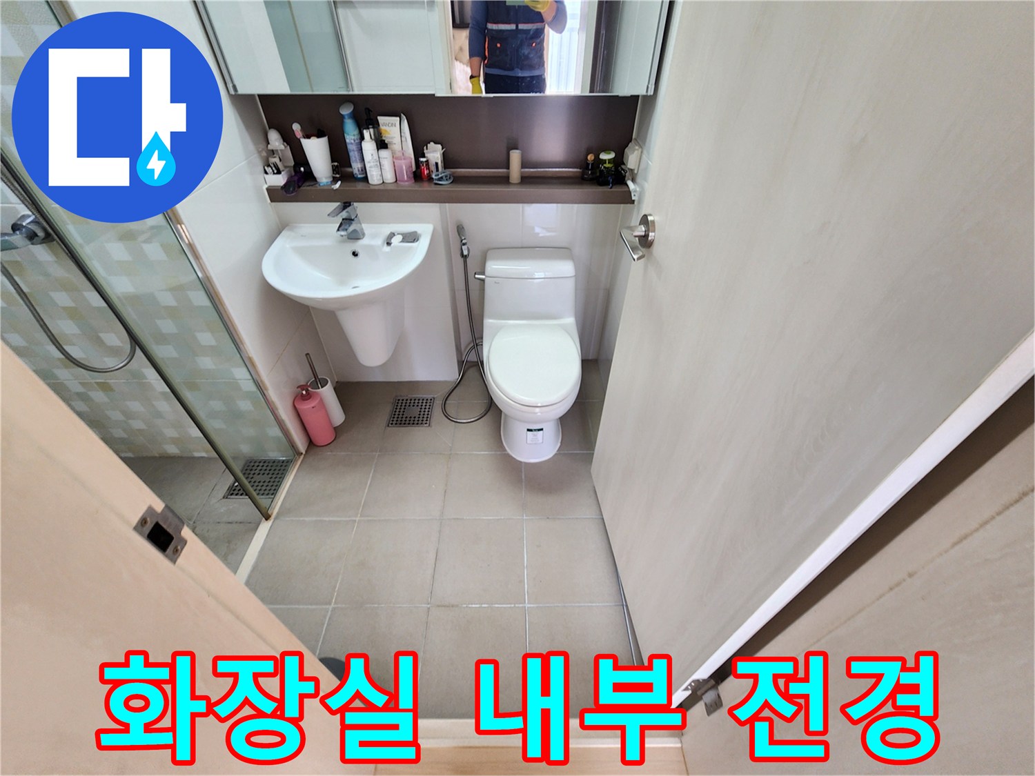 화장실 세면대와 양변기 그리고 샤워부스가 보이는 욕실 내부 모습입니다.