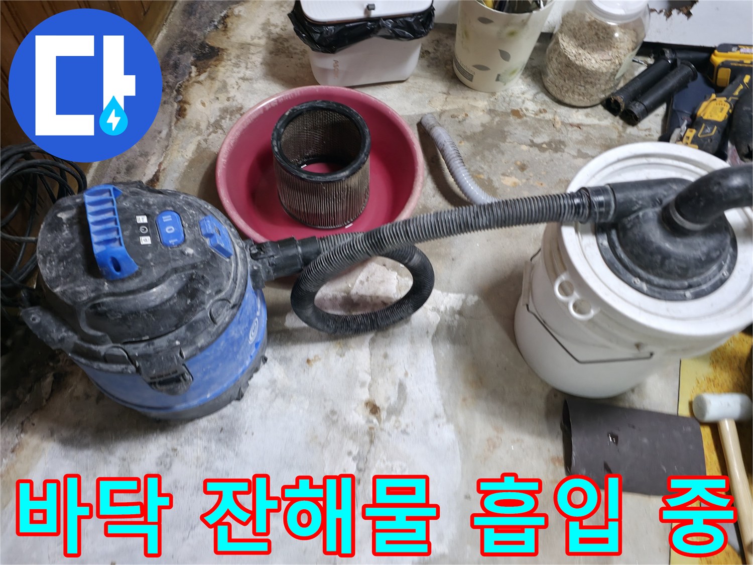 공사 현장의 젖은 모래와 먼지를 청소기로 작업하는 장면입니다.