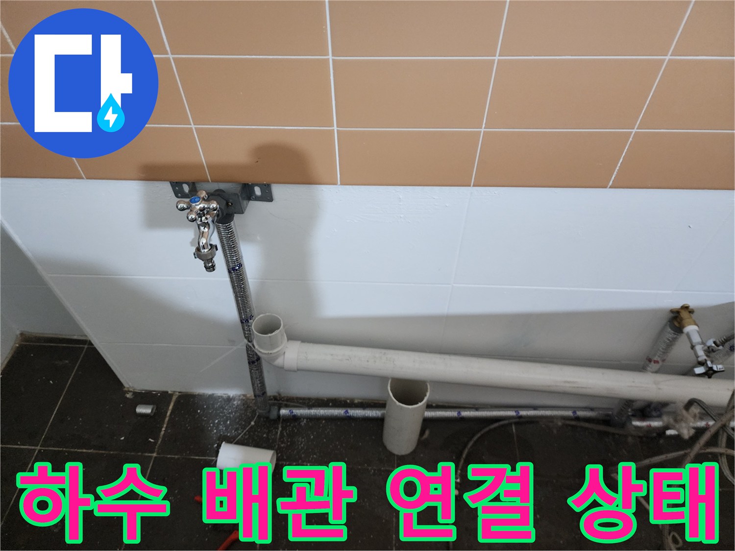벽면 타일 아래로 지나가는 하수 배관과 수전 부위 상세 촬영