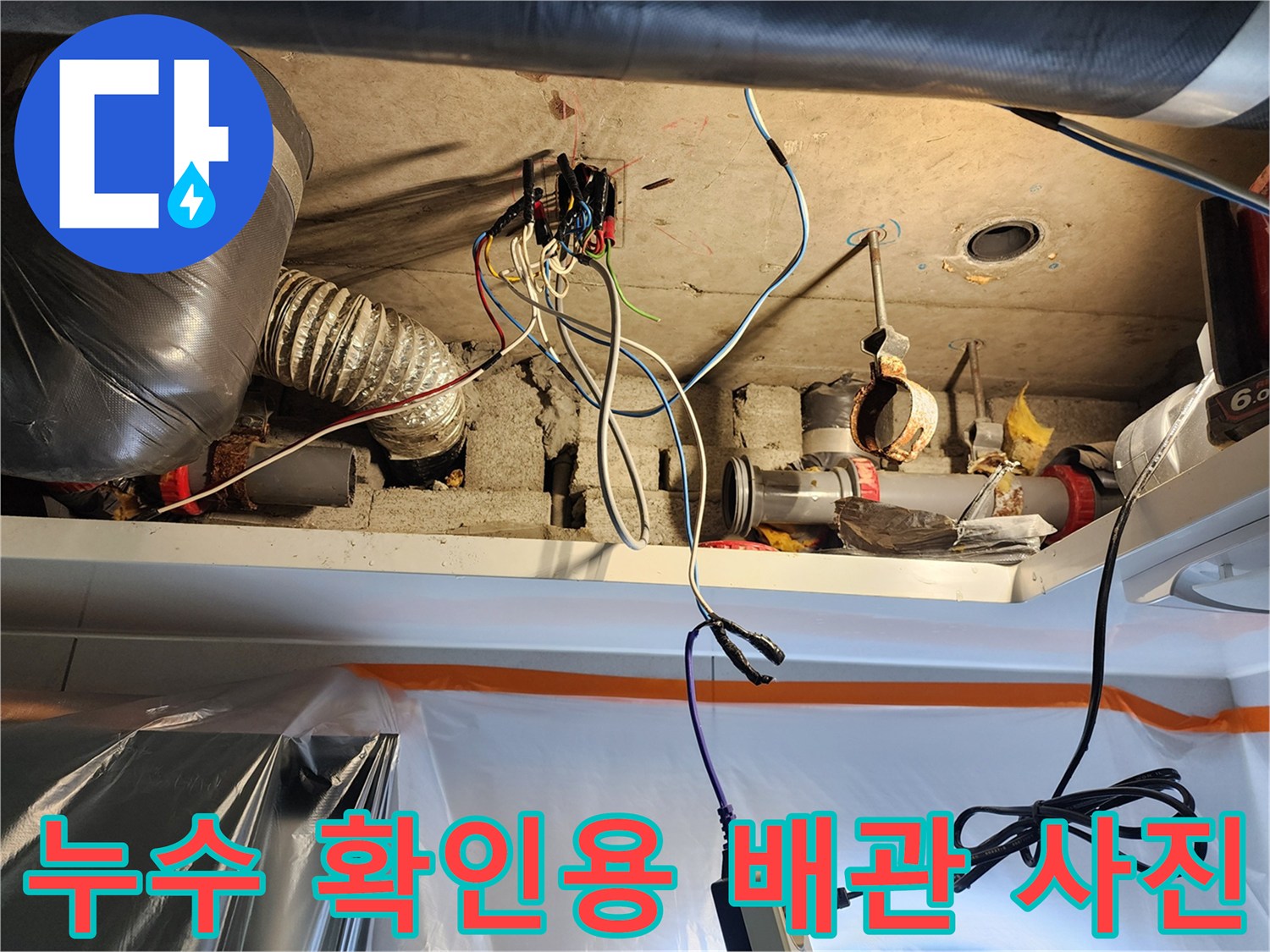 천장 내부의 PVC 하수관과 전기 배선이 복잡하게 구성된 현장 모습입니다.