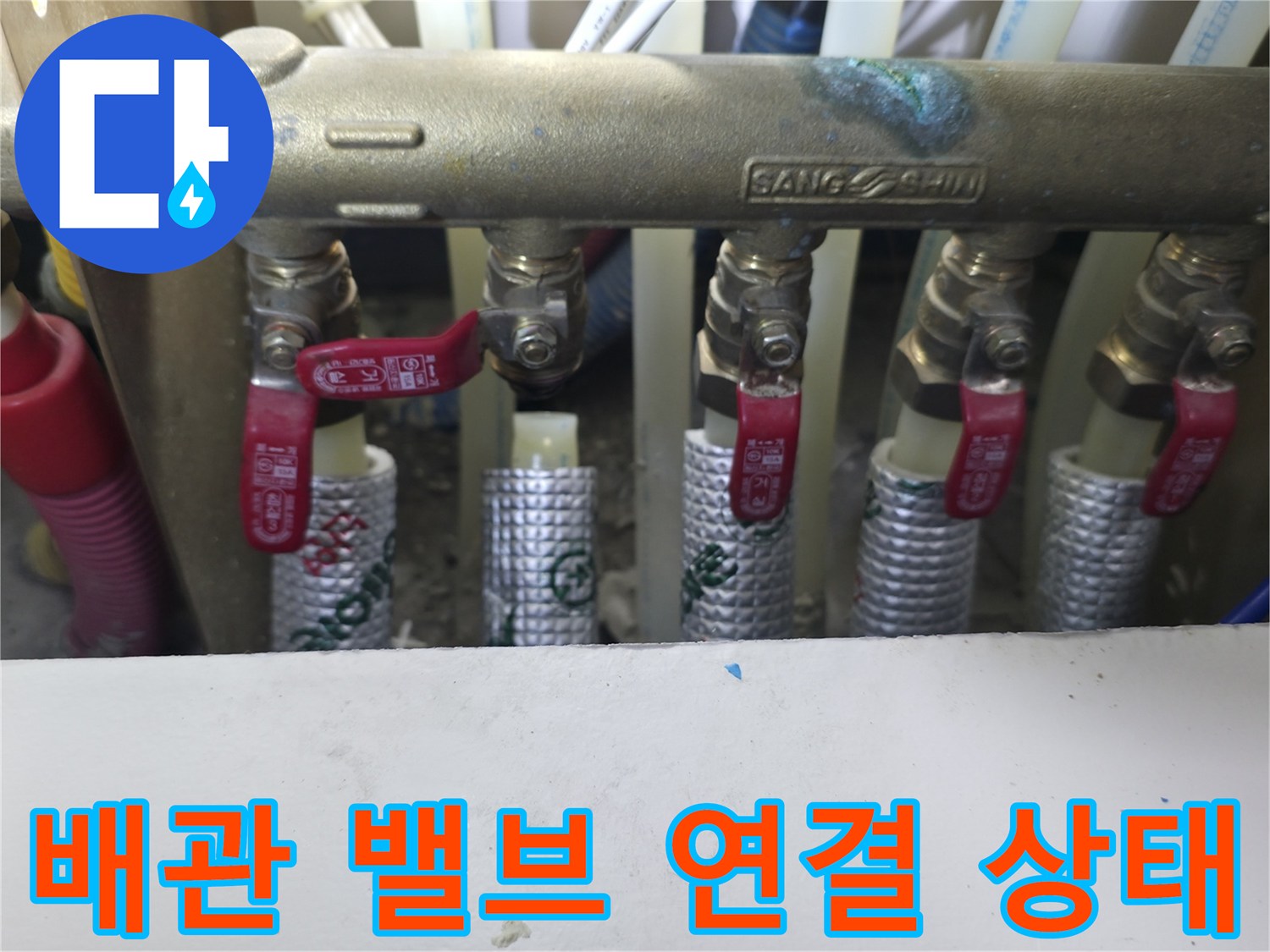 빨간색 손잡이 밸브가 달린 금속 분배기 근접 사진