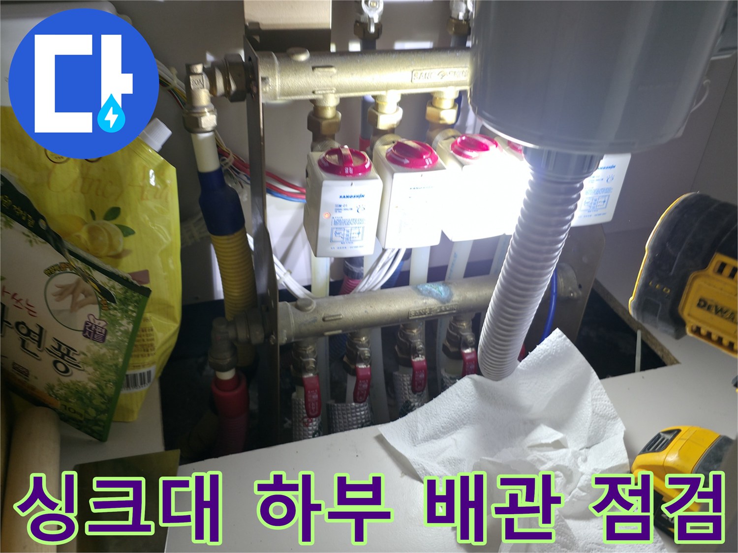 싱크대 아래 분배기-물샘 확인을 위해 조사 중인 수도 배관 연결 부위