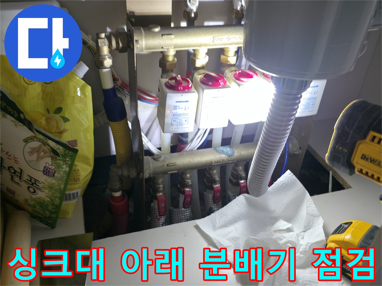 싱크대 하부 배관-분배기 밸브와 연결된 여러 가닥의 수도 배관들