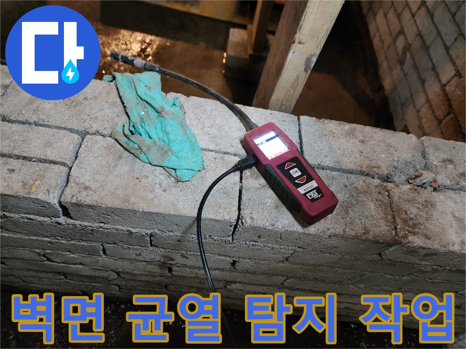 균열이 있는 벽체 사이로 연결된 누수 탐지용 센서와 호스