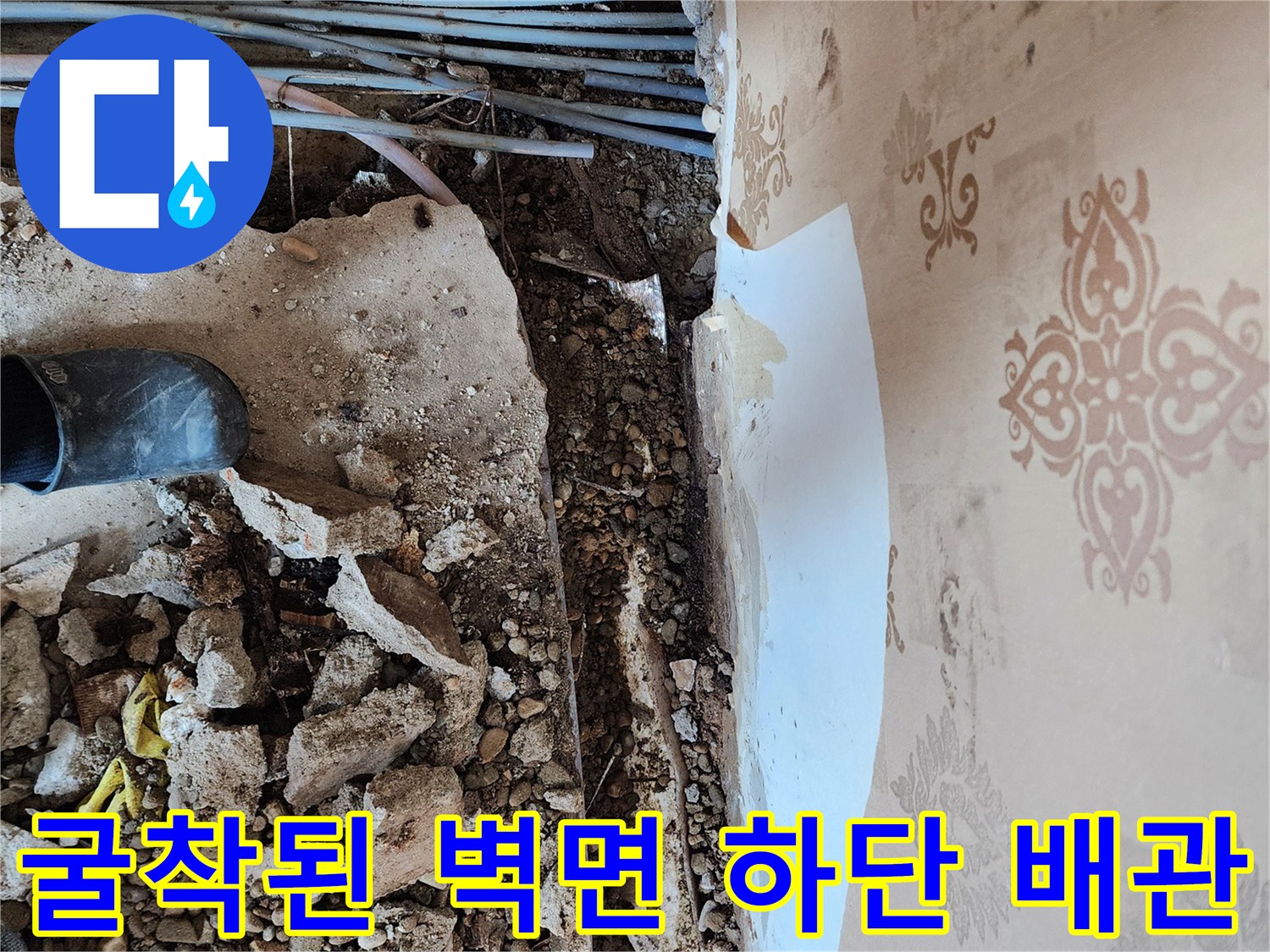 벽면 아래쪽 흙을 파내어 드러난 여러 가닥의 매립 배선 및 배관