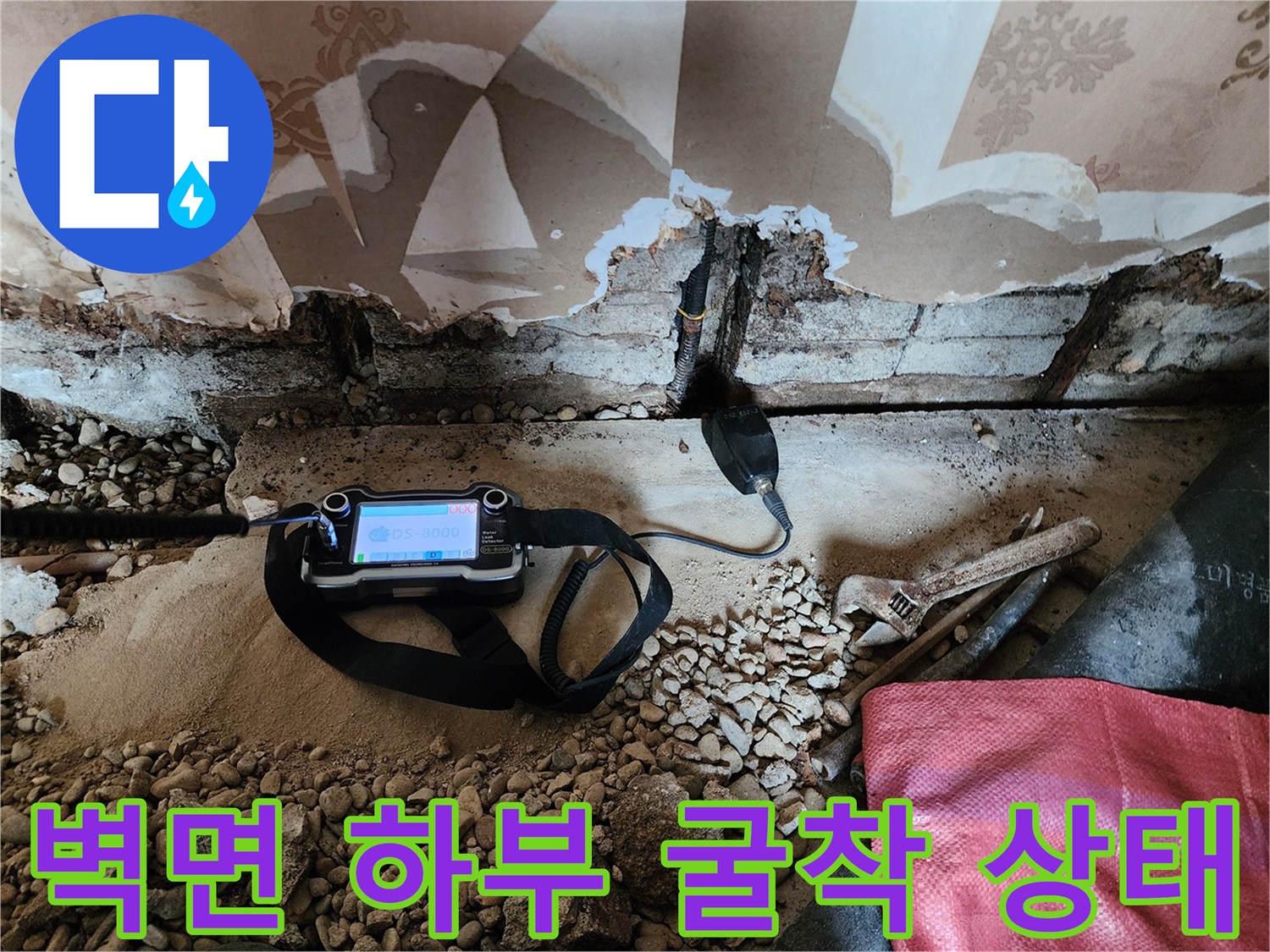 벽지와 타일 경계 부위의 배관 누수를 확인하기 위해 작업 중인 모습입니다.