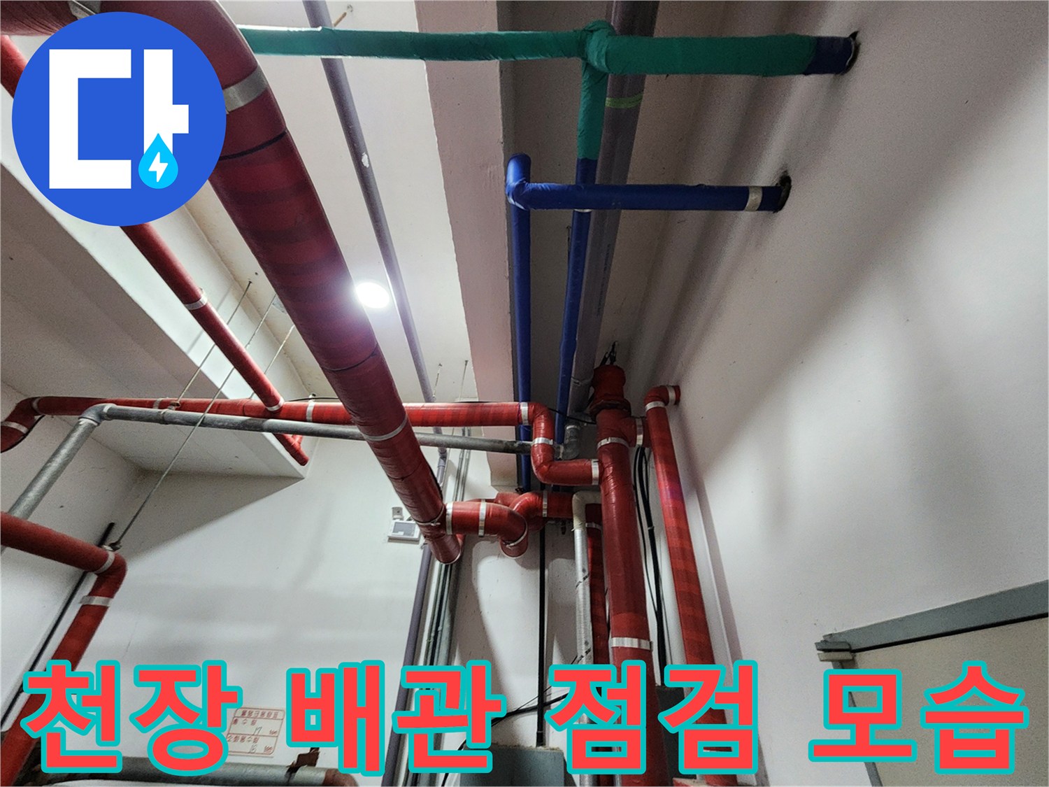 천장에 설치된 빨간색과 파란색 배관의 상태를 확인하는 현장 사진