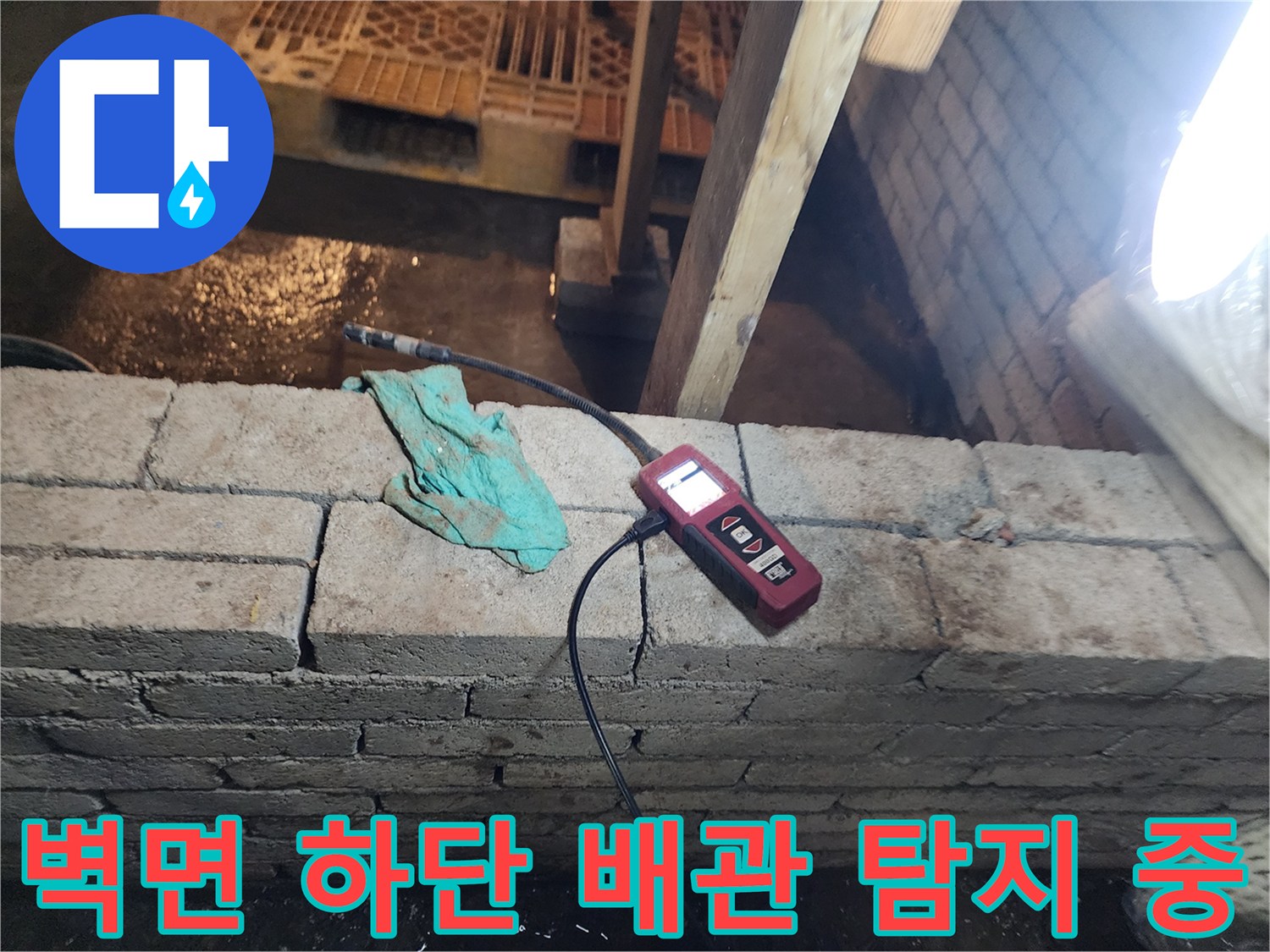 콘크리트 및 벽돌 부근에 가스 탐지기를 대고 누수 지점을 확인하고 있는 모습입니다.