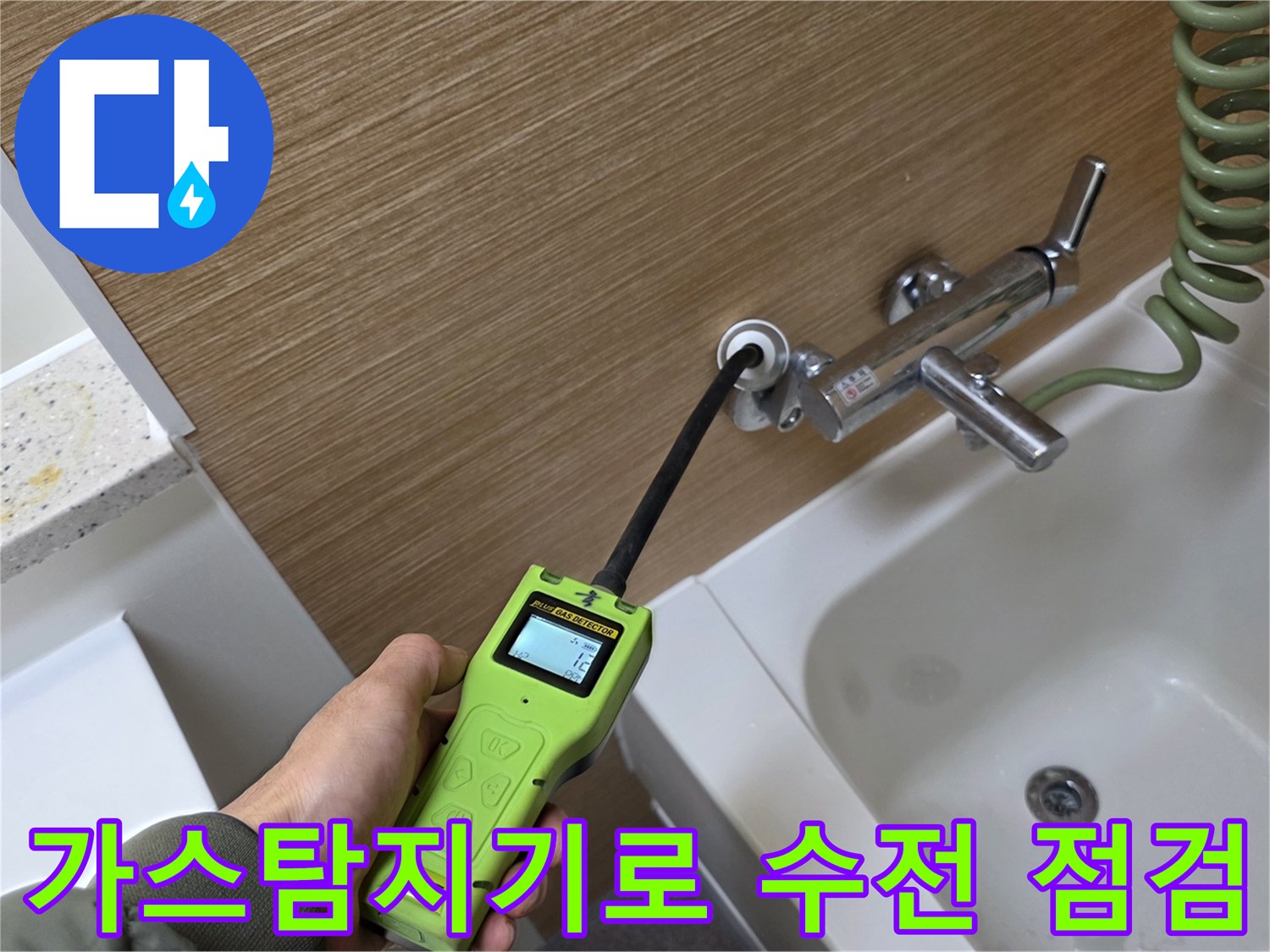 가스 탐지기를 사용하여 욕실 벽면 수전 연결 부위의 누수 지점을 추적하는 모습입니다.