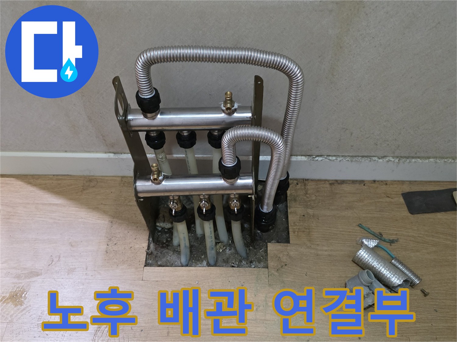 금속 분배기와 유연한 은색 자재의 배관이 연결된 모습