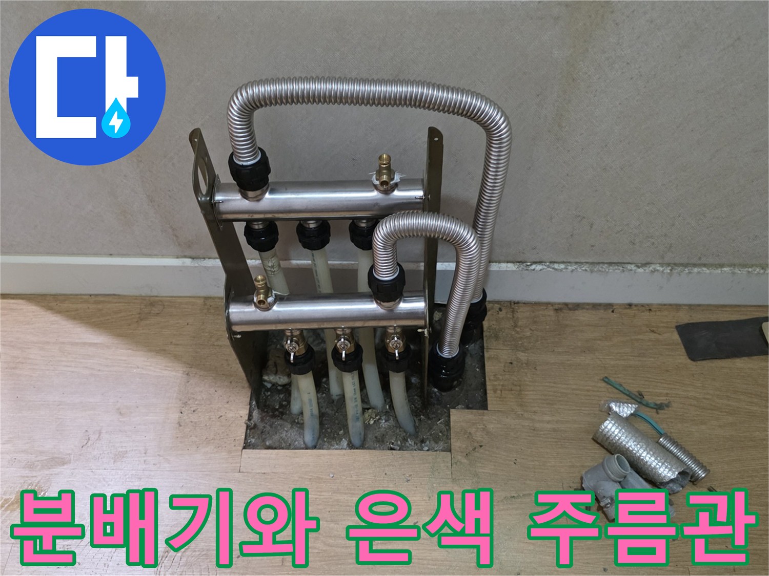 욕실 벽체 내부의 누수 부위-금속 분배기와 연결된 은색 유연 배관