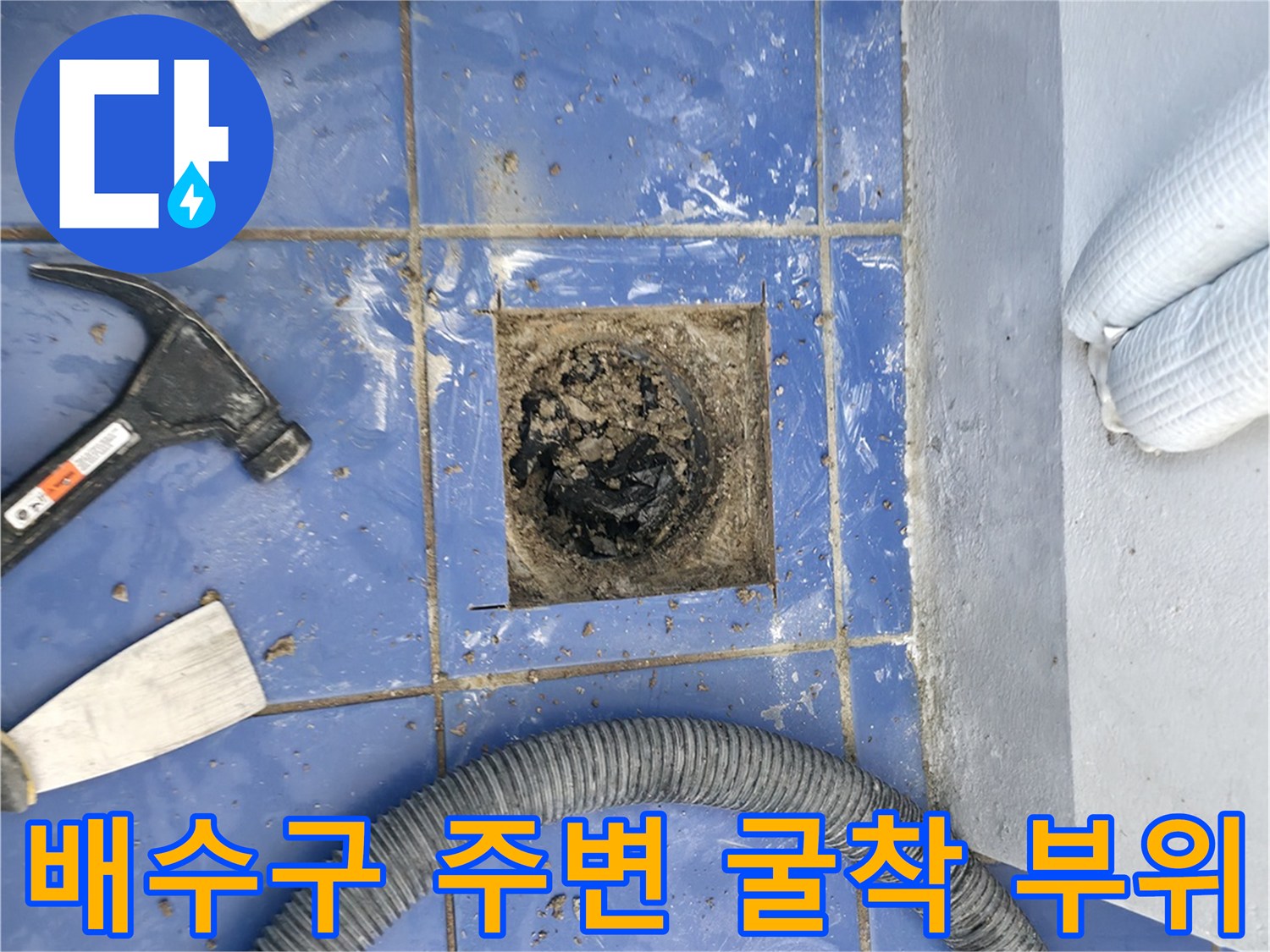 세탁실 바닥 배수구 주변을 파내어 내부 배관이 드러난 사진