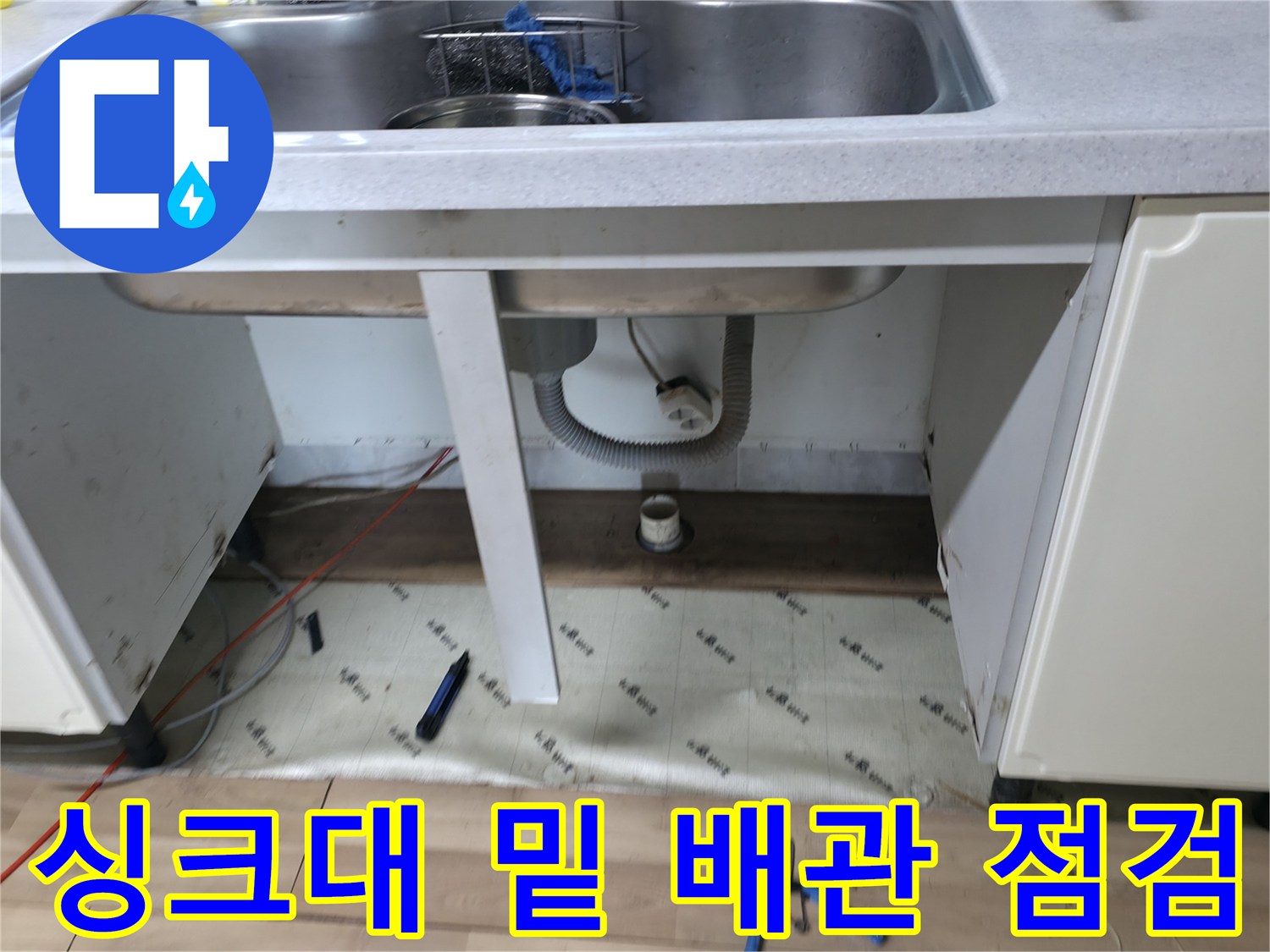 싱크대 하단 배수구와 벽면 연결 배관의 누수 여부를 조사하고 있습니다.
