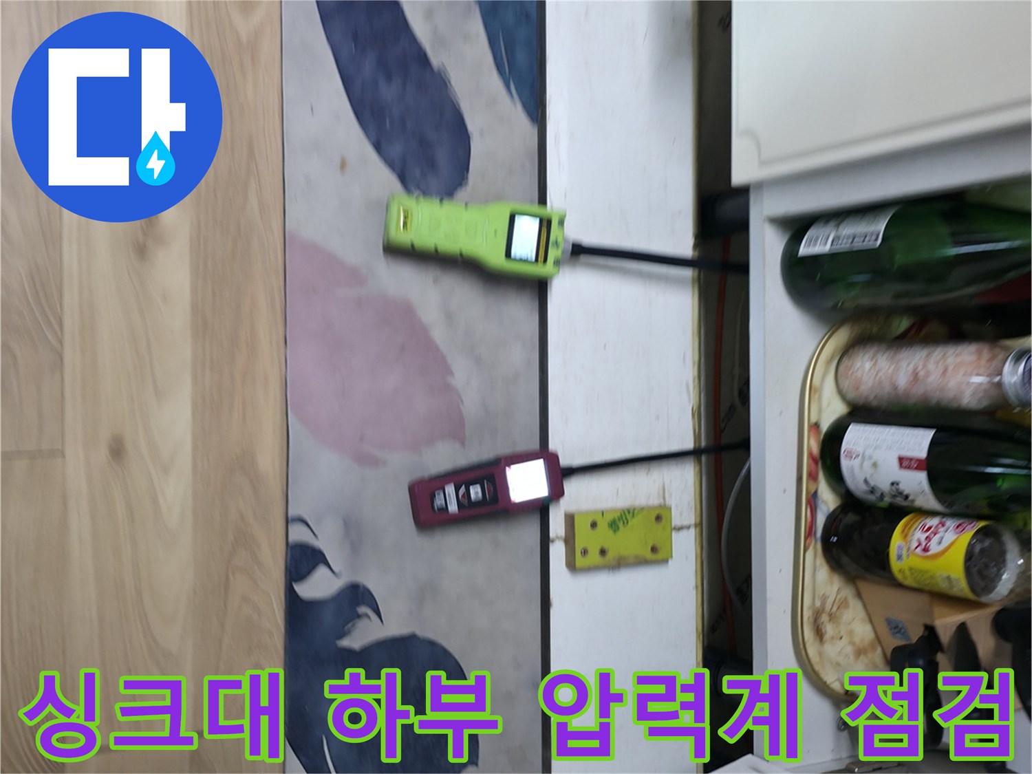 싱크대 하부장 아래에 설치된 배관 압력계와 가스 탐지기 모습