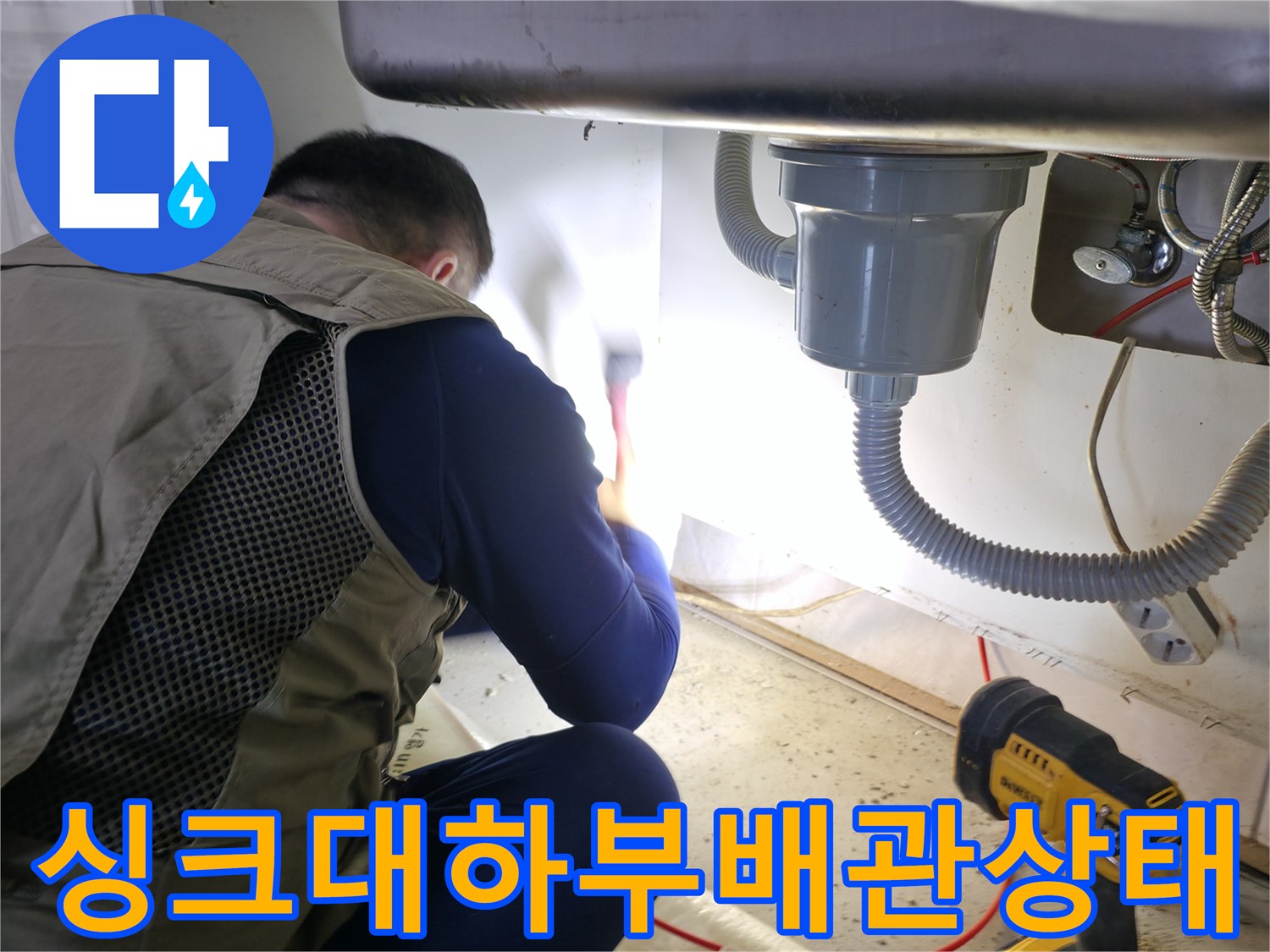 주방 싱크대 하부장 안쪽의 배수 호스와 수도 연결 부위 점검 모습