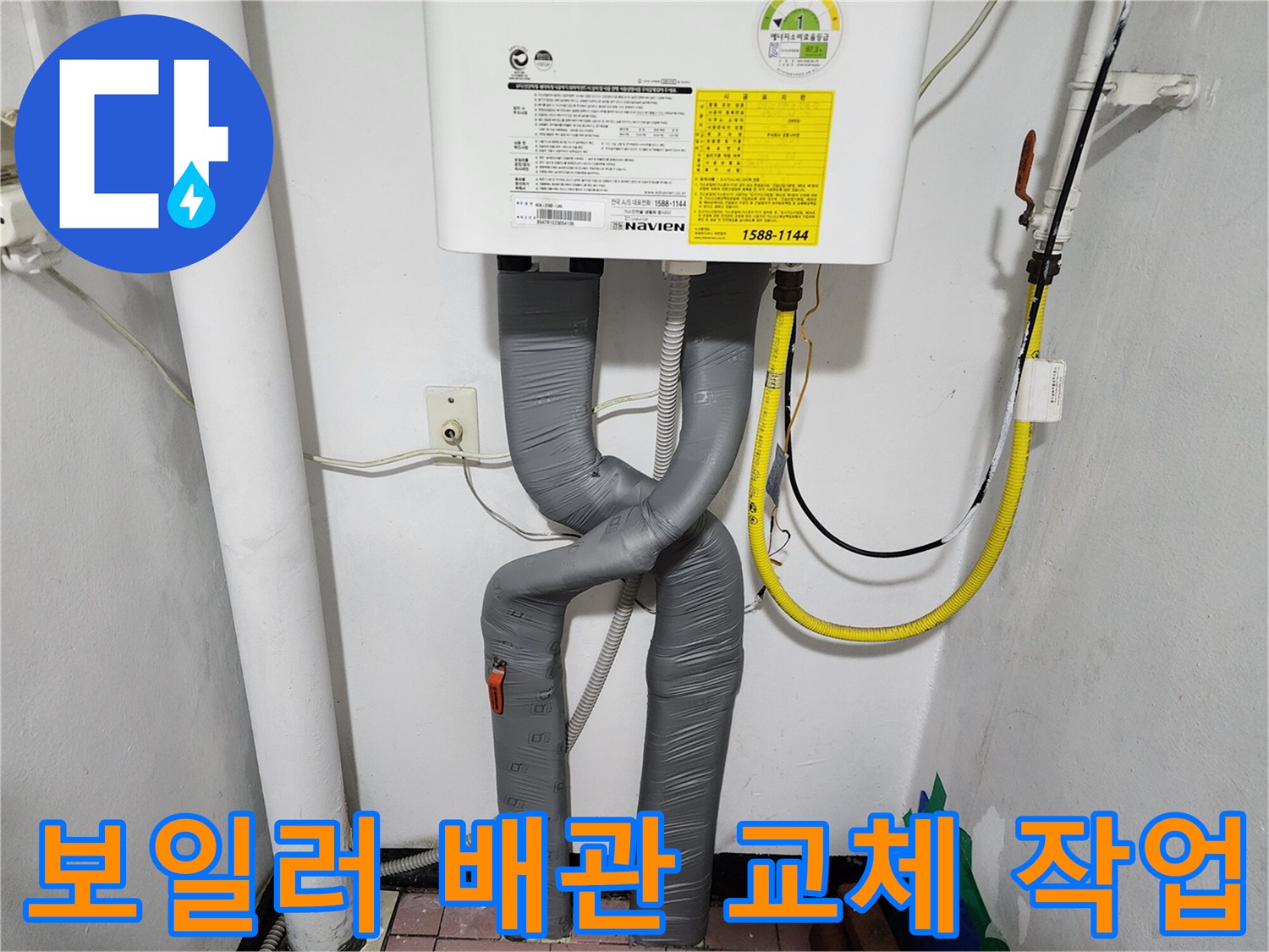 보일러 하단에 새롭게 설치된 회색 주름관 배관 모습입니다.